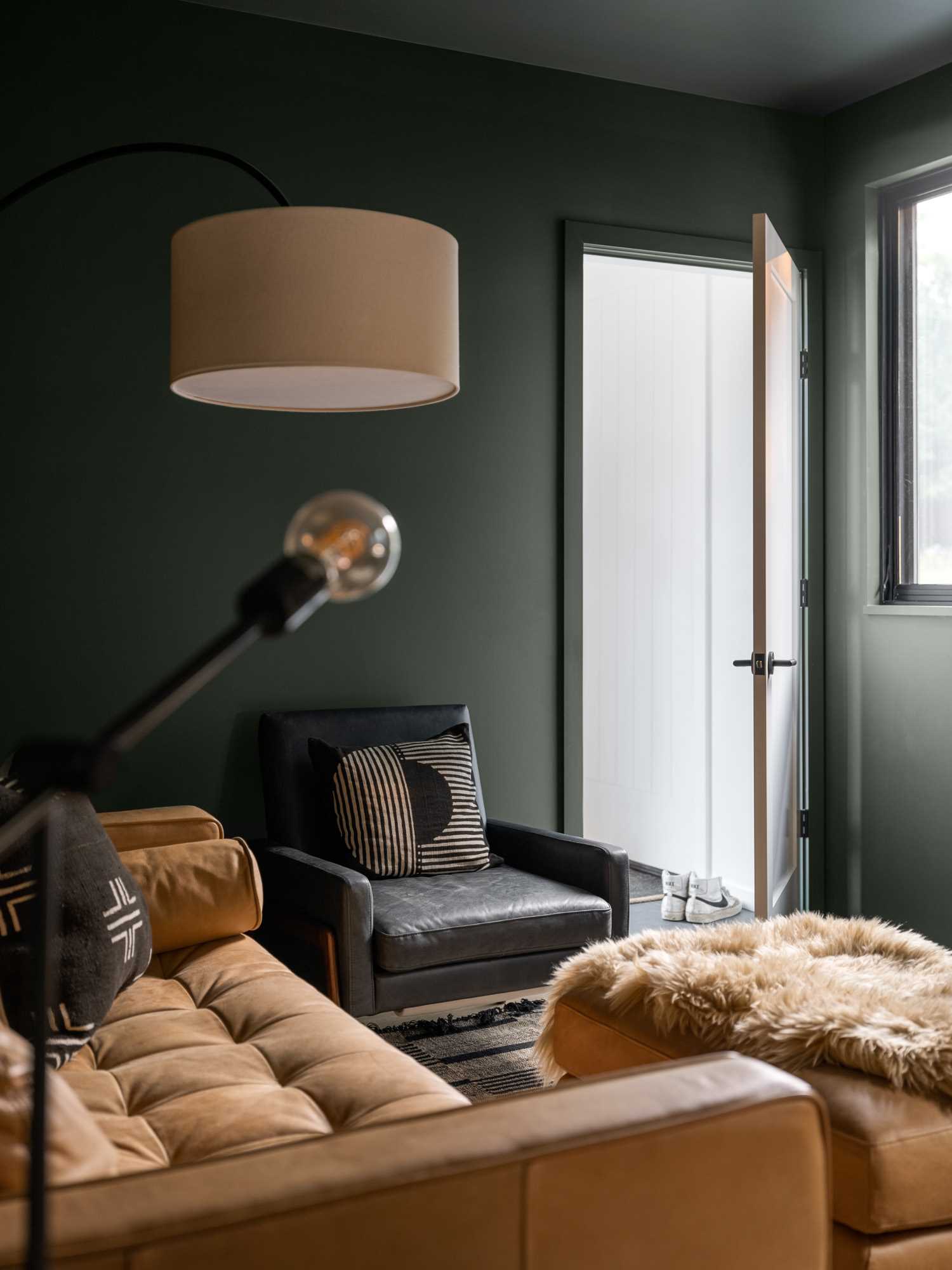 A secondary living room that's been finished with dark walls and cozy furniture.