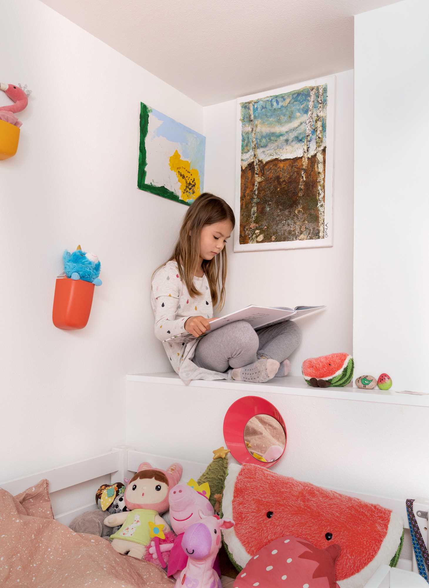 A modern kids bedroom with a small reading nook.