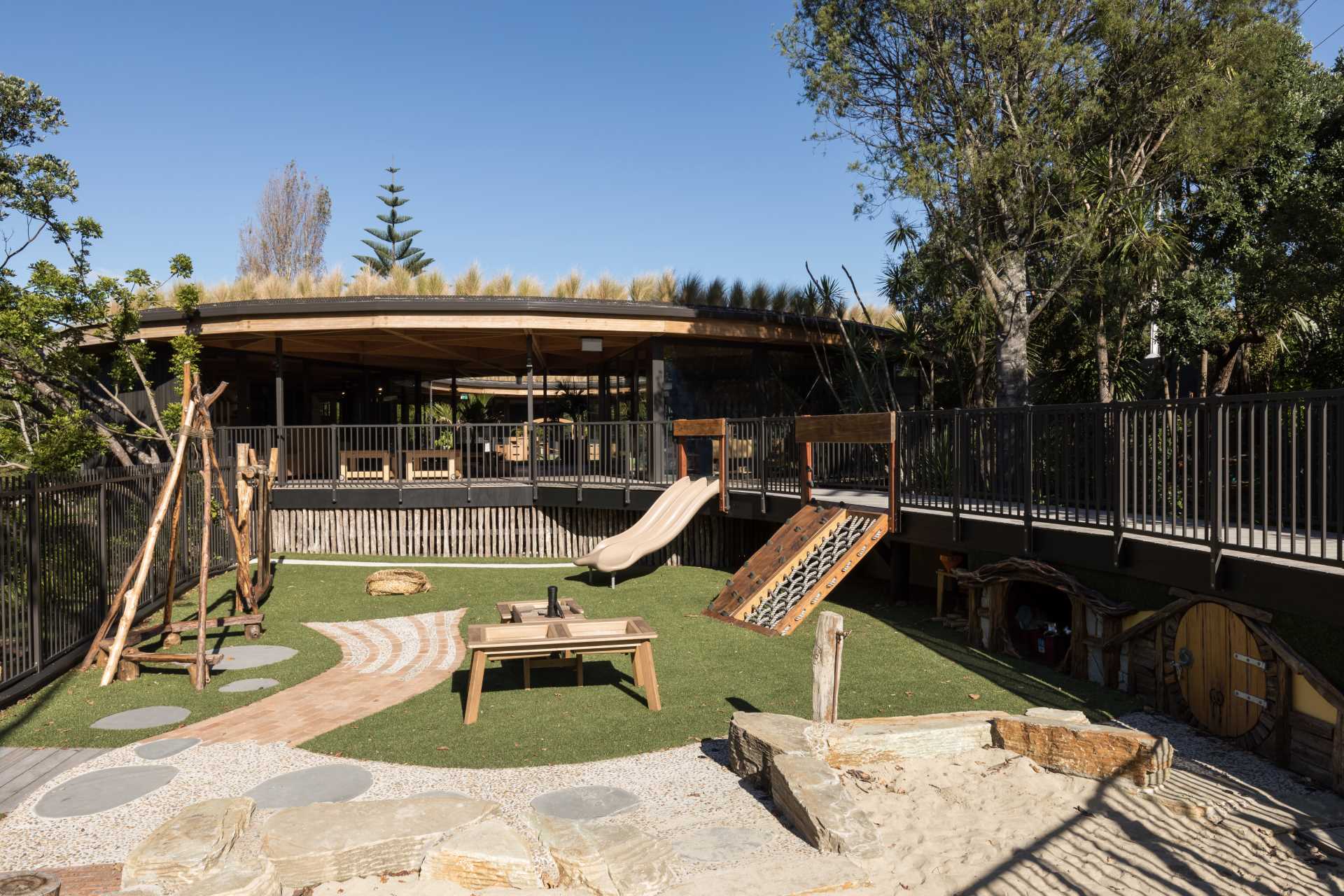 A modern playground at an early learning centre with a green roof.