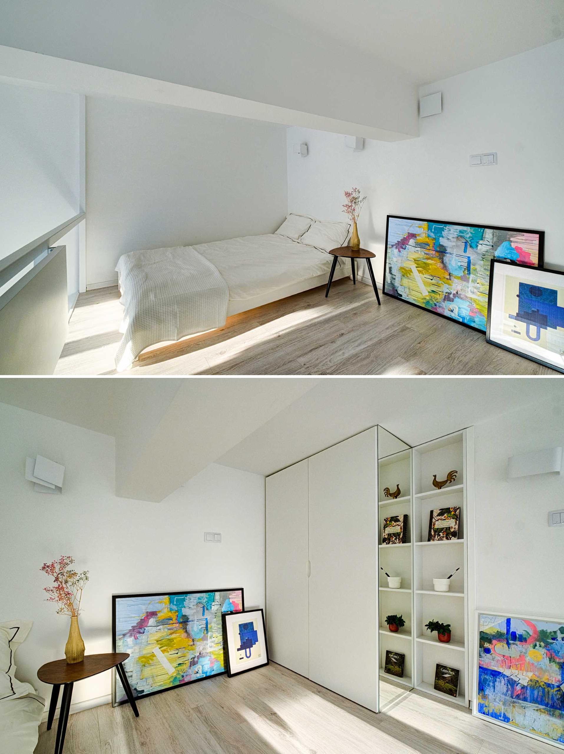 The loft bedroom is simply furnished, with a bed, side table, and artwork, as well as floor-to-ceiling closet.