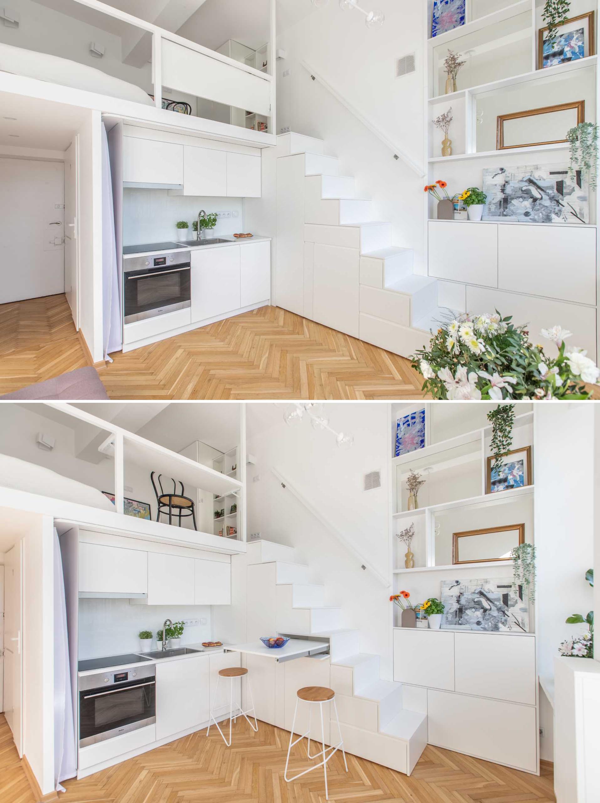 A small apartment with a loft bedroom, has a pull-out table underneath the stairs that acts as a dining table or additional countertop.