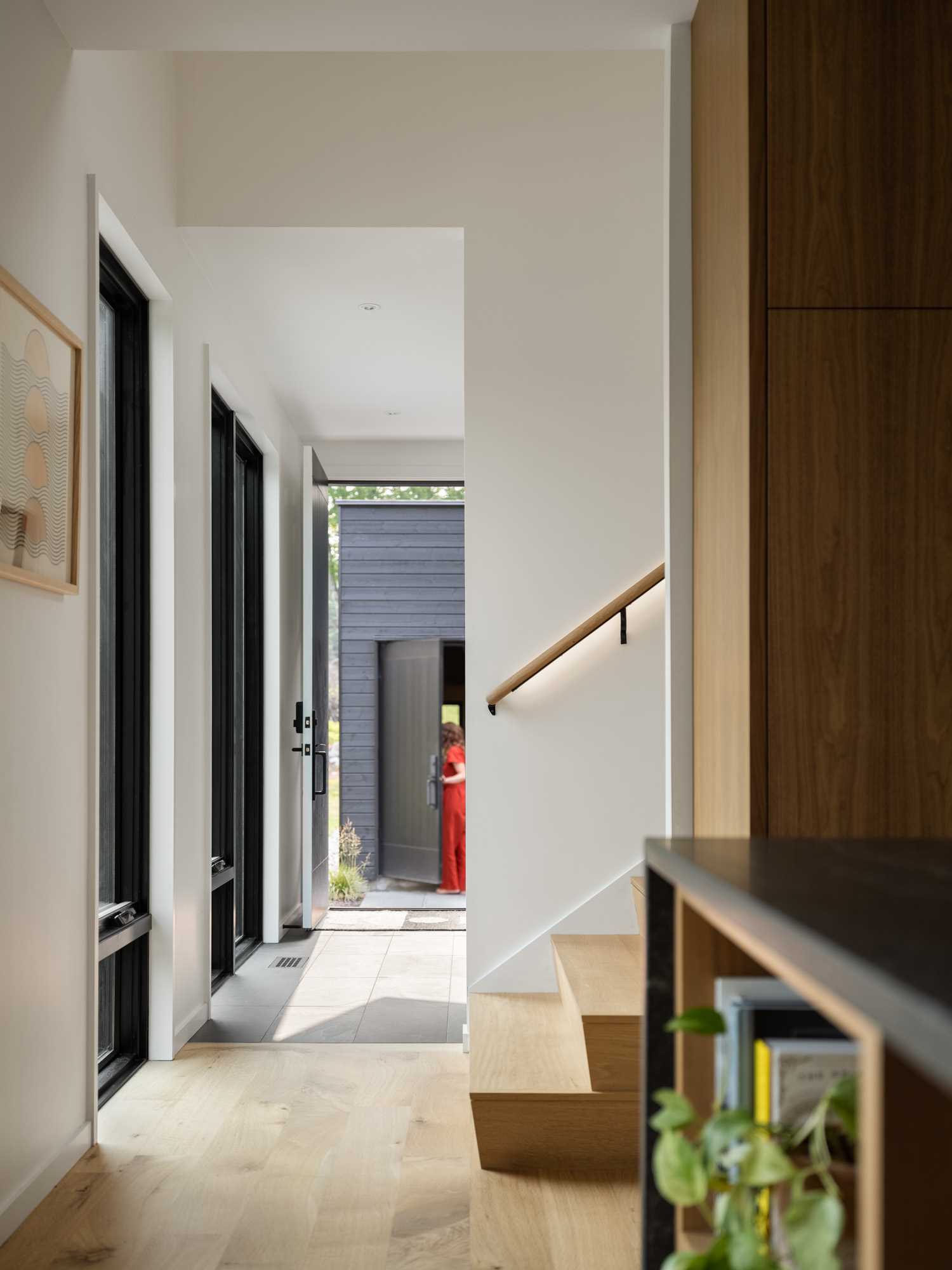 Wood stairs lead to the upper floor of this modern home, while a handrail includes hidden lighting.
