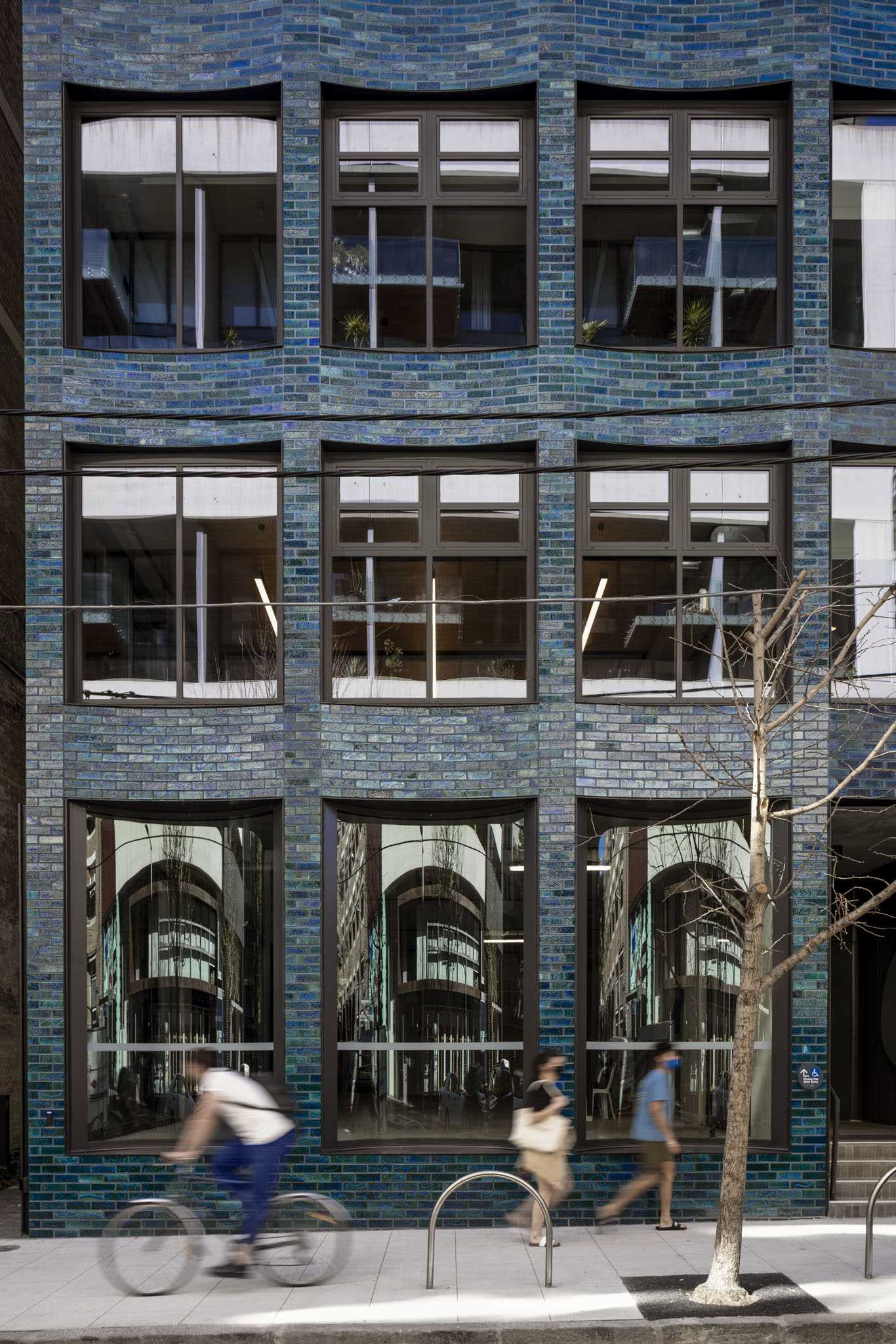 A commercial building with blue glazed bricks and a scalloped facade.