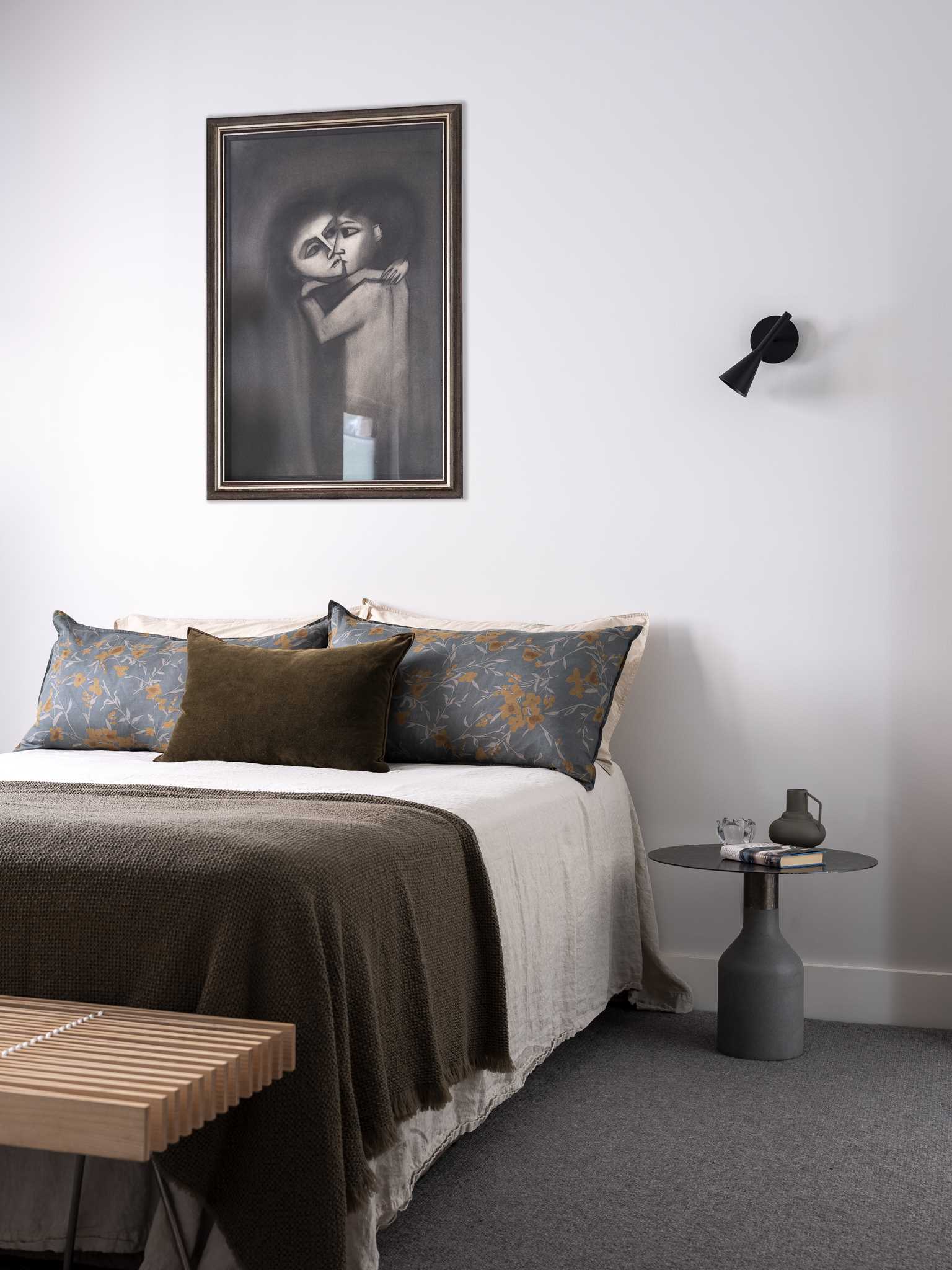 A contemporary bedroom with light walls and grey carpet.