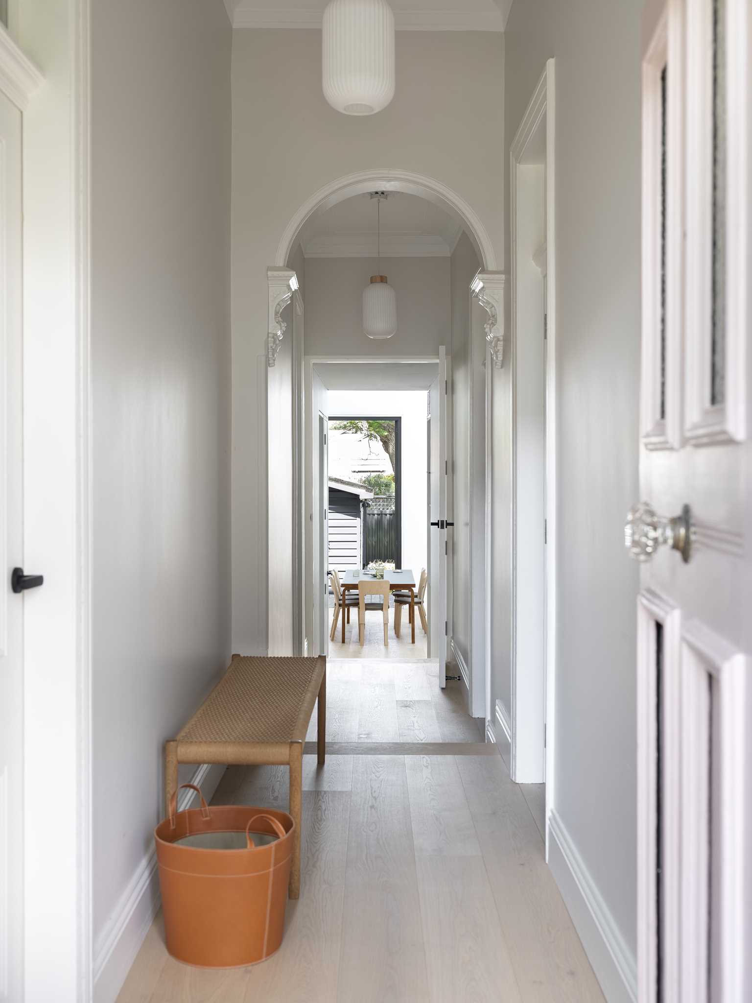 The updated entryway includes a wood bench and a view of the dining room at the rear of the home.