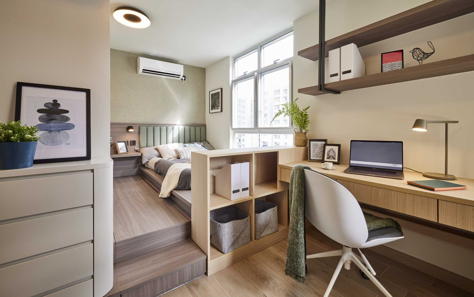 A modern bedroom with a raised bed, and built-in home office.