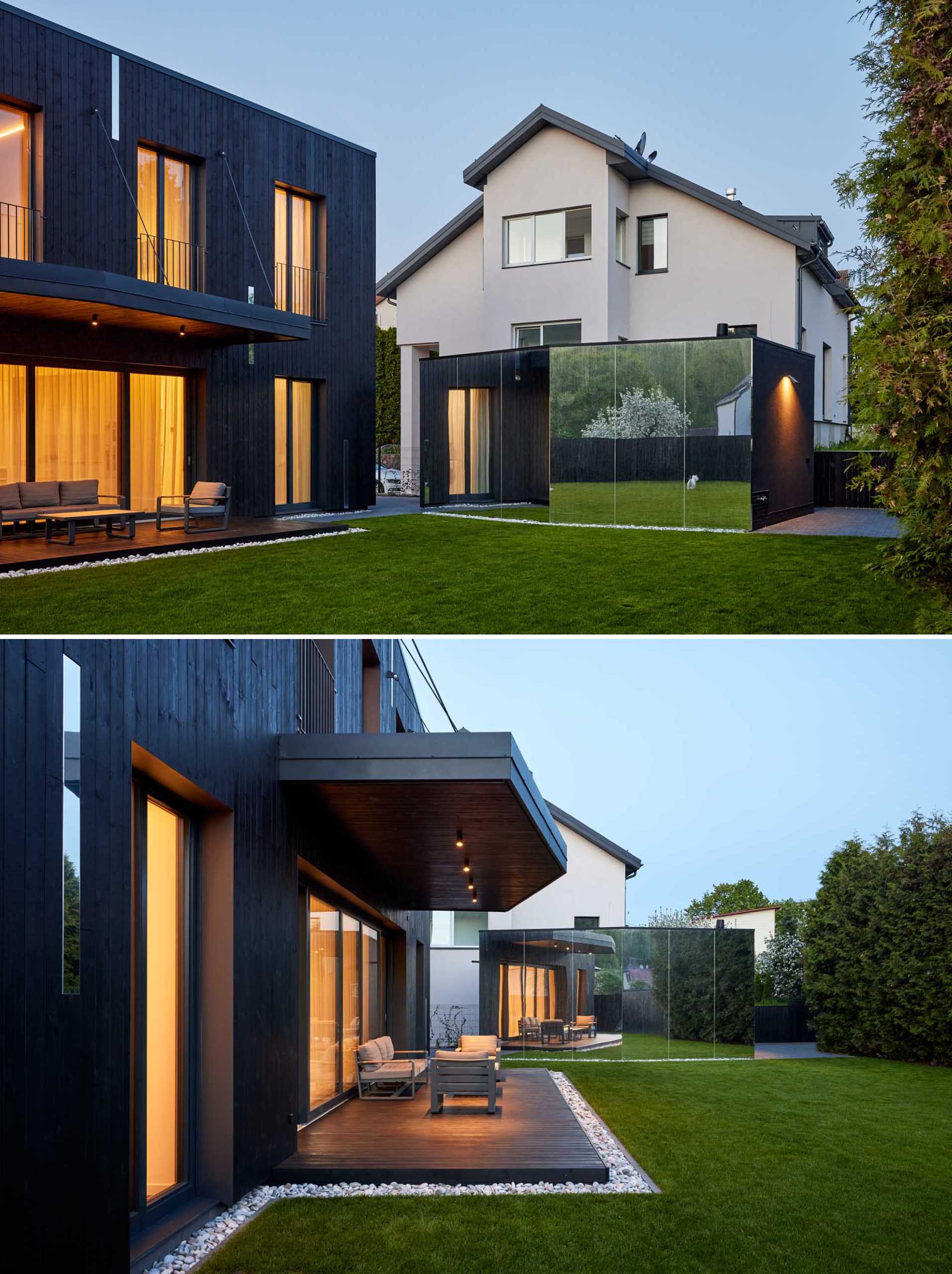 A modern home with a detached garage that has a mirrored exterior wall.