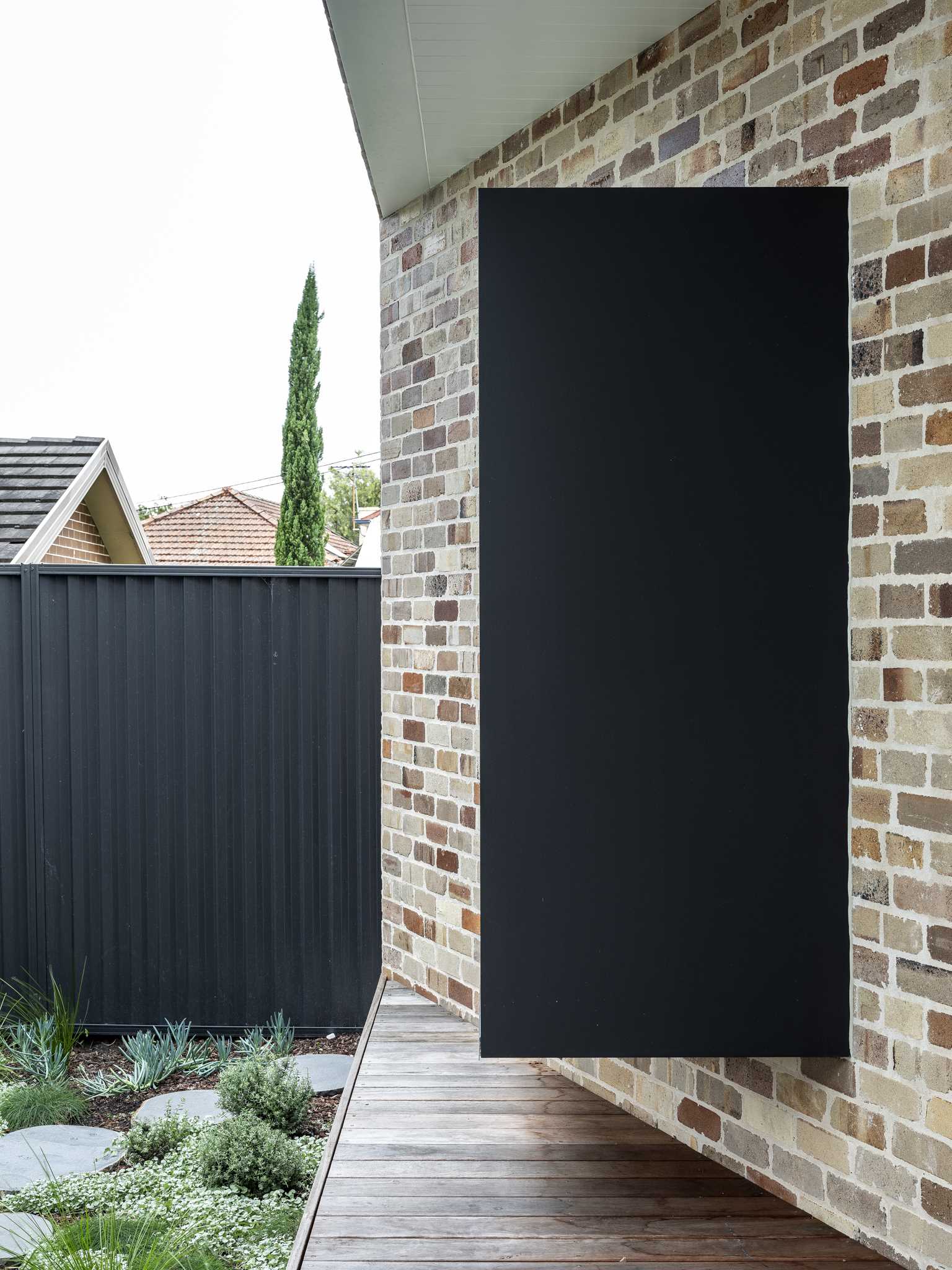 A recycled brick addition with a black-framed window seat.