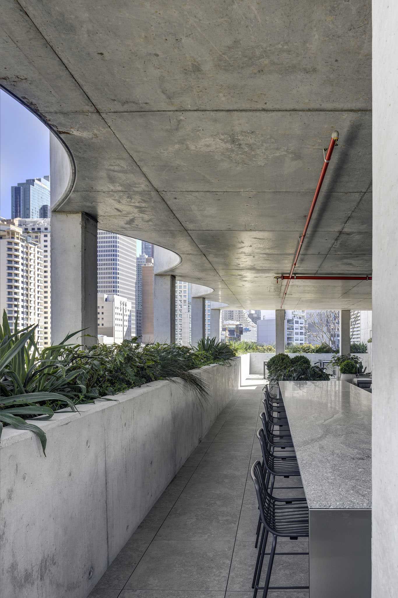 A rooftop patio with built-in concrete planters wrapping around the exterior.