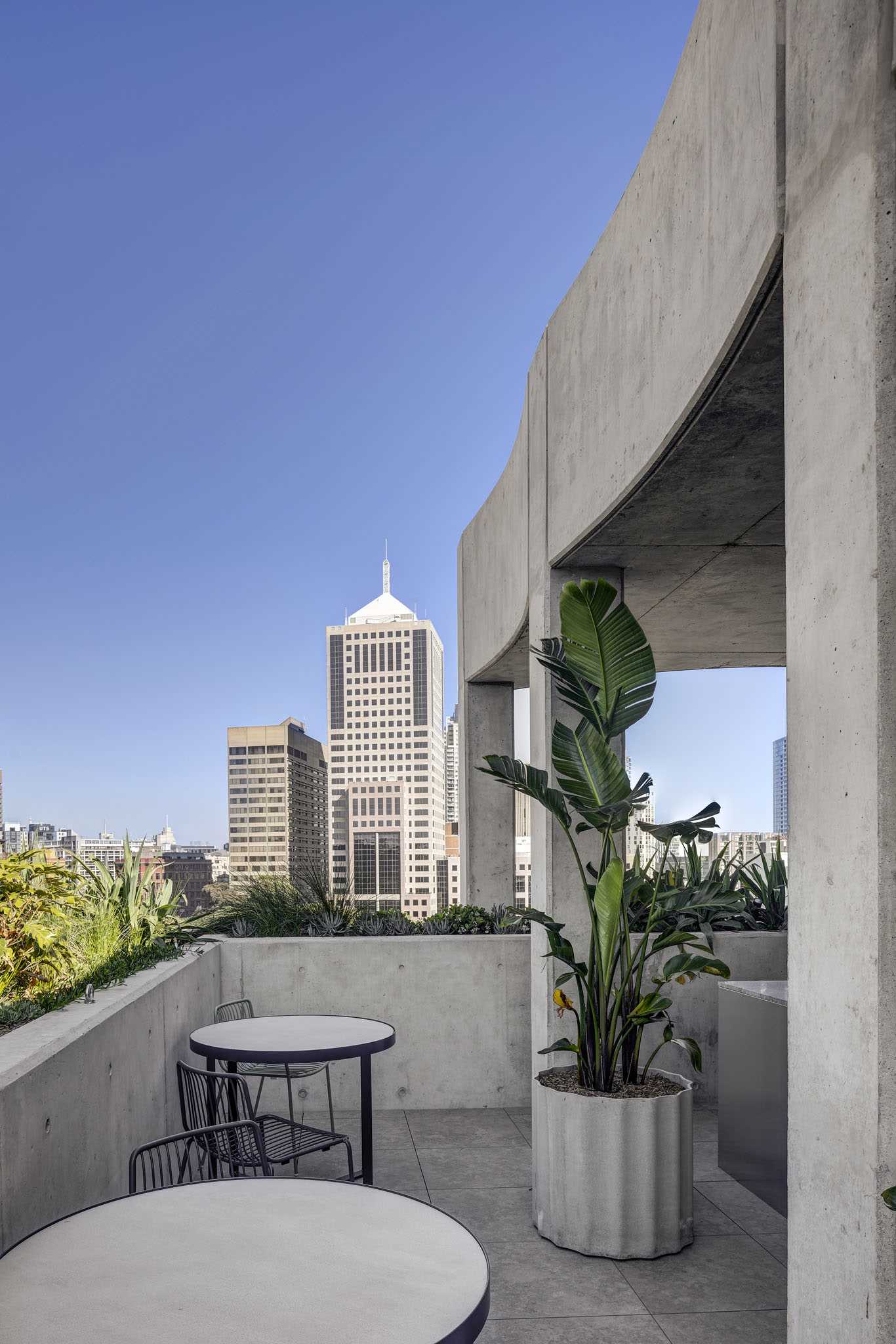 A rooftop patio with built-in and standalone concrete planters.