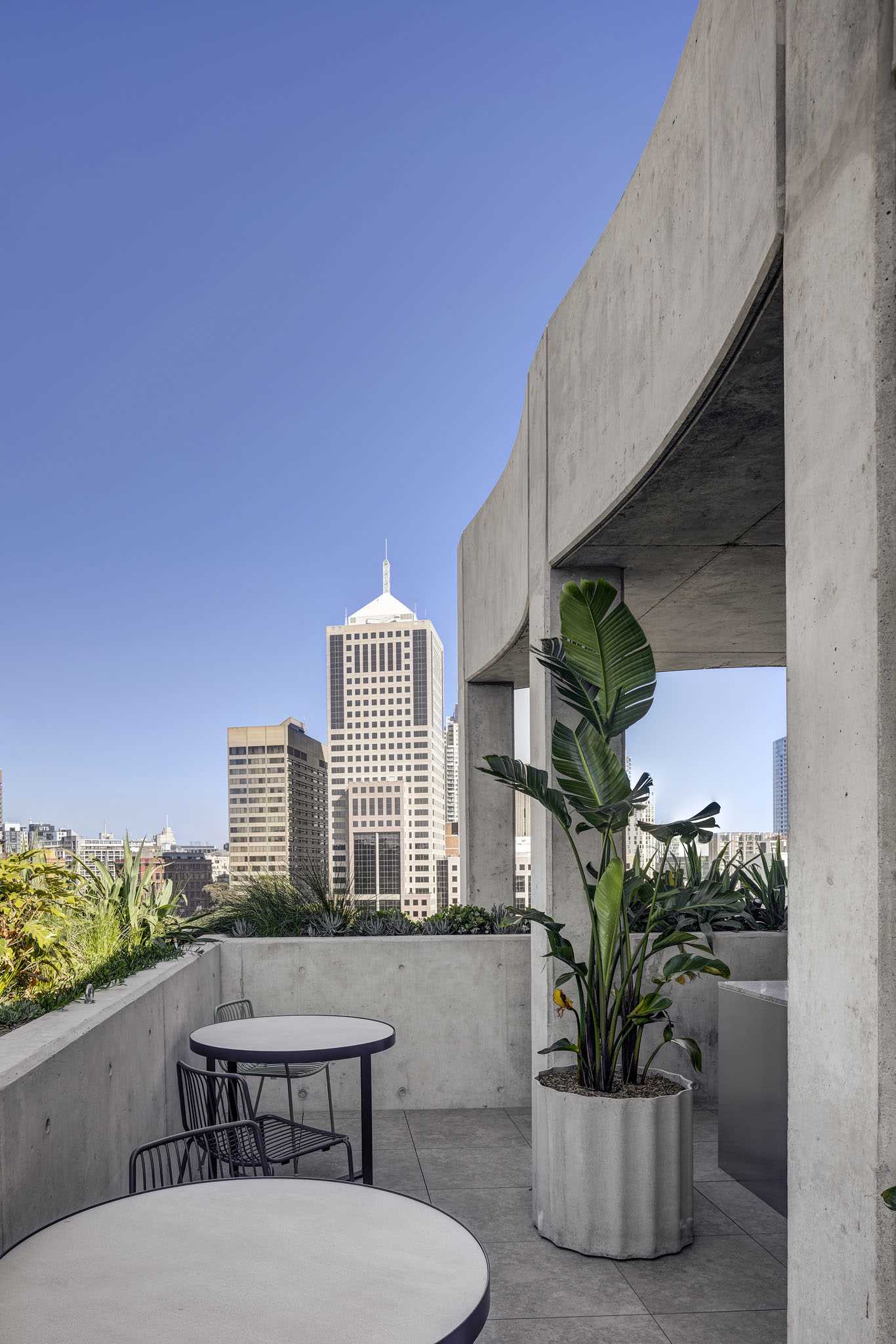 A rooftop patio with built-in and standalone concrete planters.