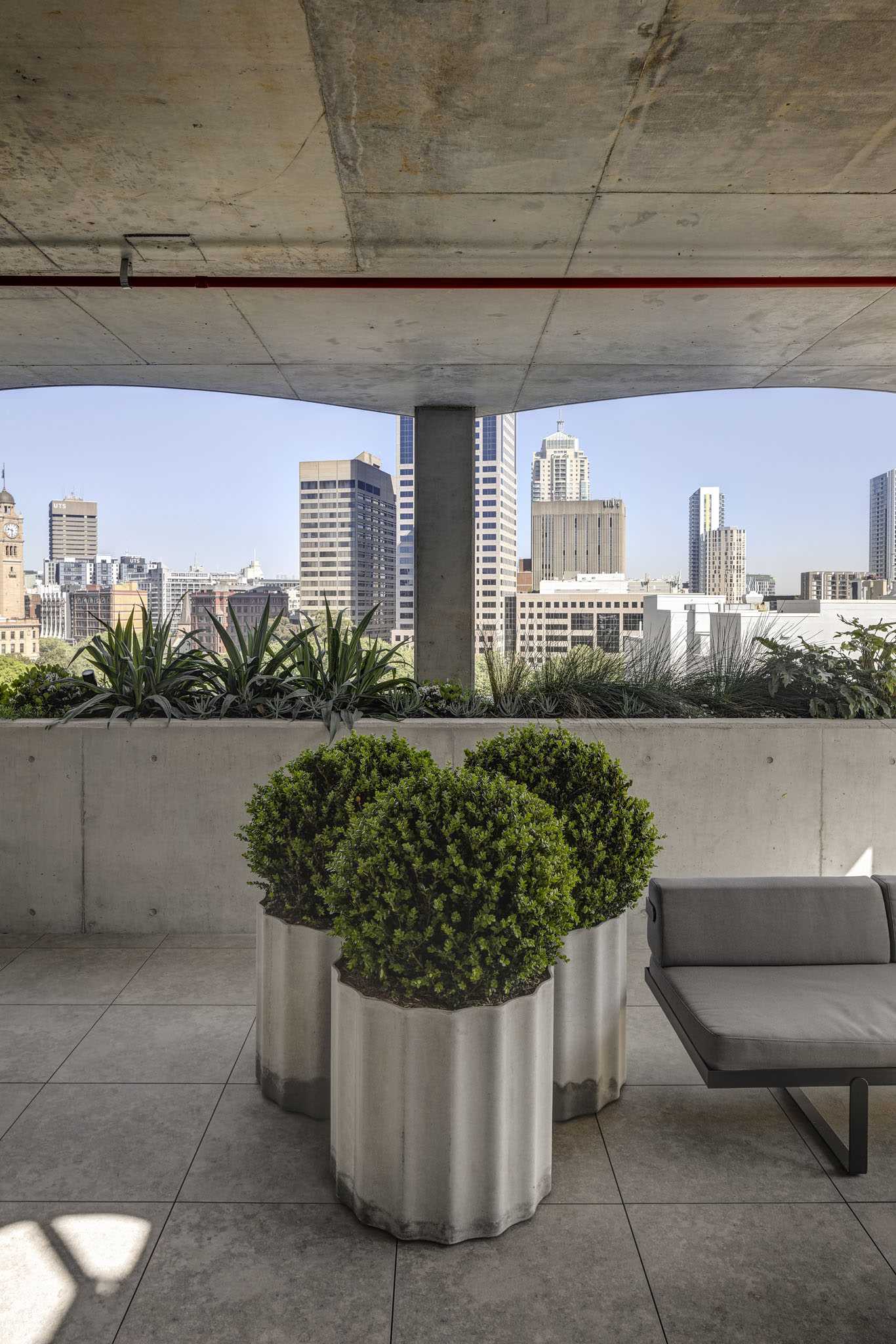 A rooftop patio with concrete planters.