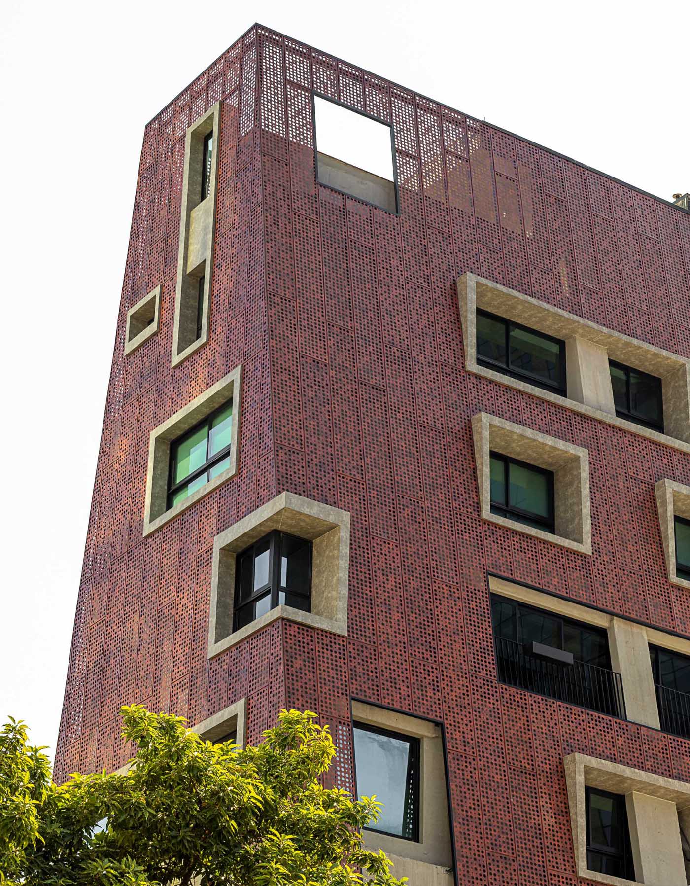 In order to obtain lightness and transparency for the bold building, the aluminum panels have perforations in different sizes, allowing the view of the surrounding area to be seen from within the building.