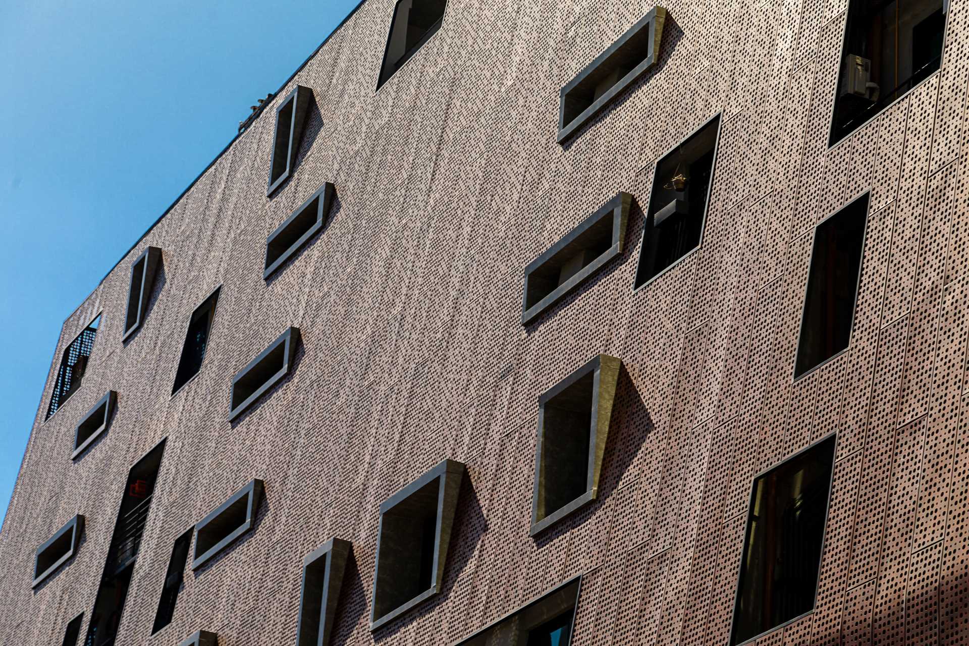A modern building with perforated aluminum panel facade.