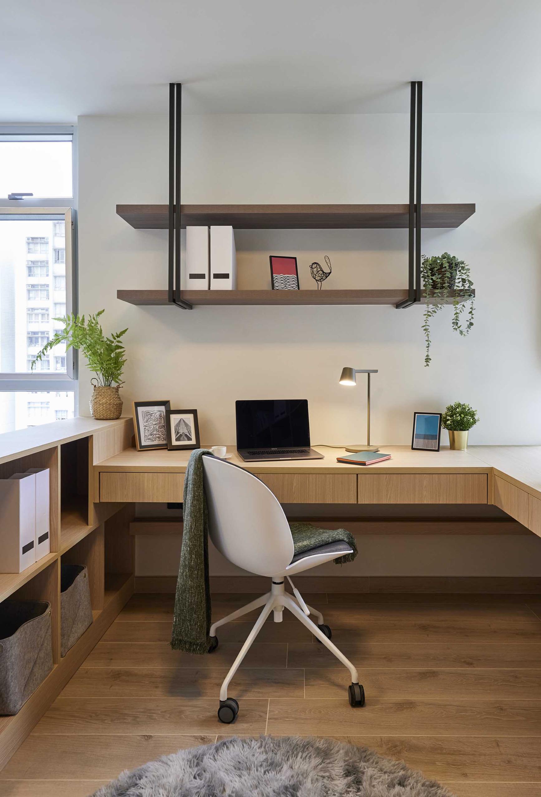 This modern built-in home office includes shelving mounted above the desk, a low cabinet on the left, and a tall cabinet with shelving on the right.
