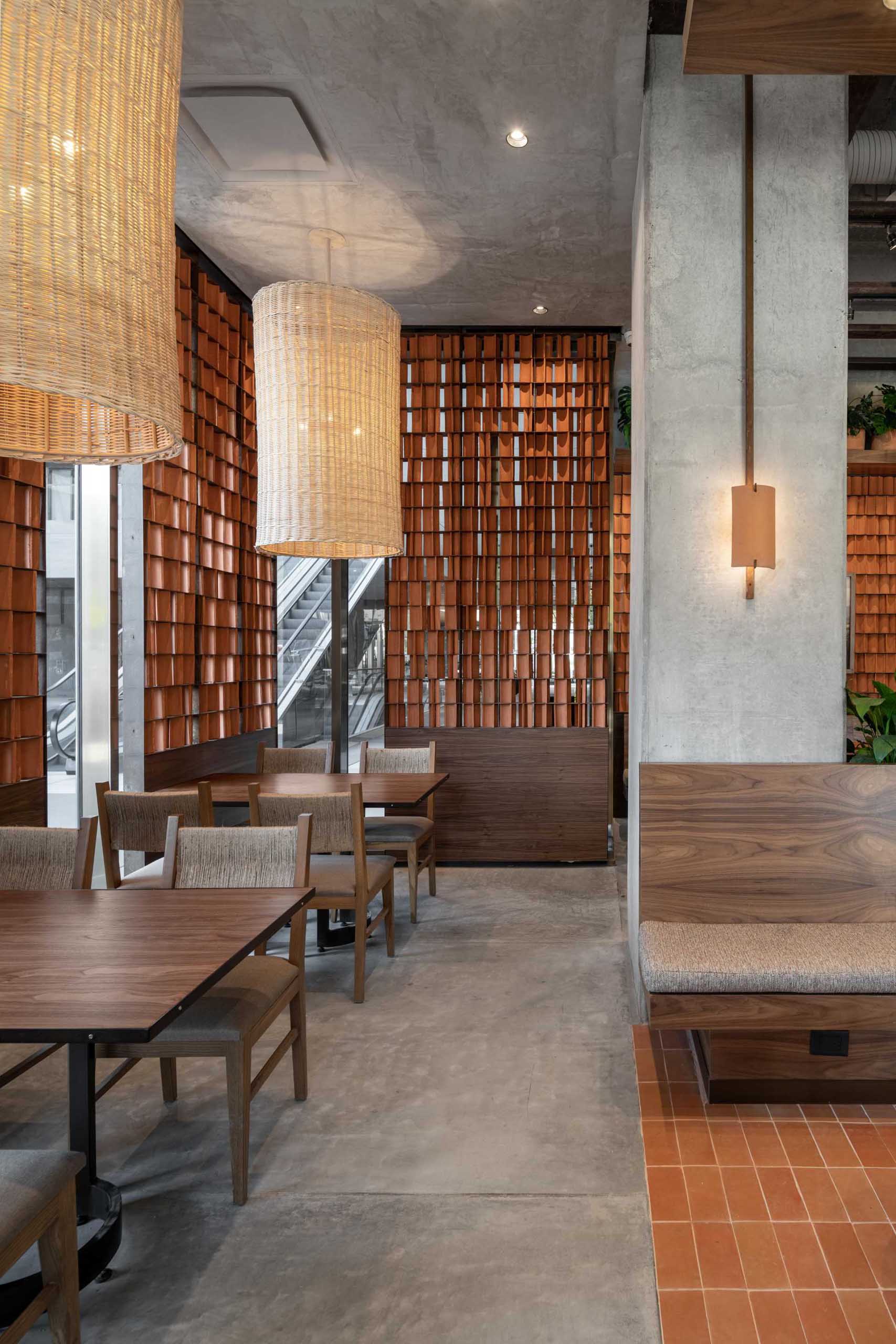 A modern coffee shop includes red clay tiles, wood, and raw concrete in its interior.