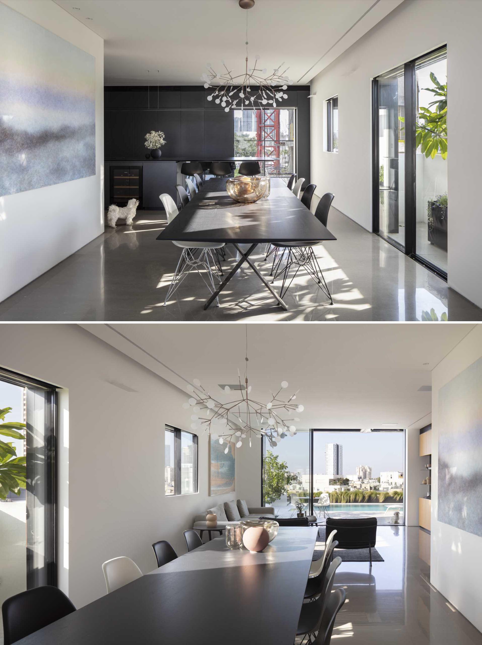 In this modern dining area, the table is covered with a black plate as thin as the kitchen island, but in this case, it is made of wood that adds warmth to the room.