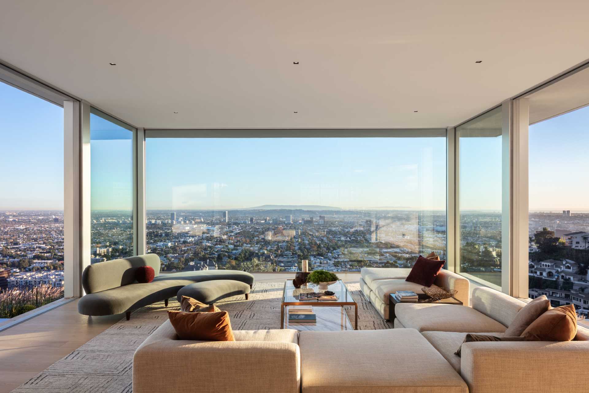 The main living room in this modern house, is positioned in a cantilevered glass box with windows on three sides, providing an unobstructed view of the landscape.