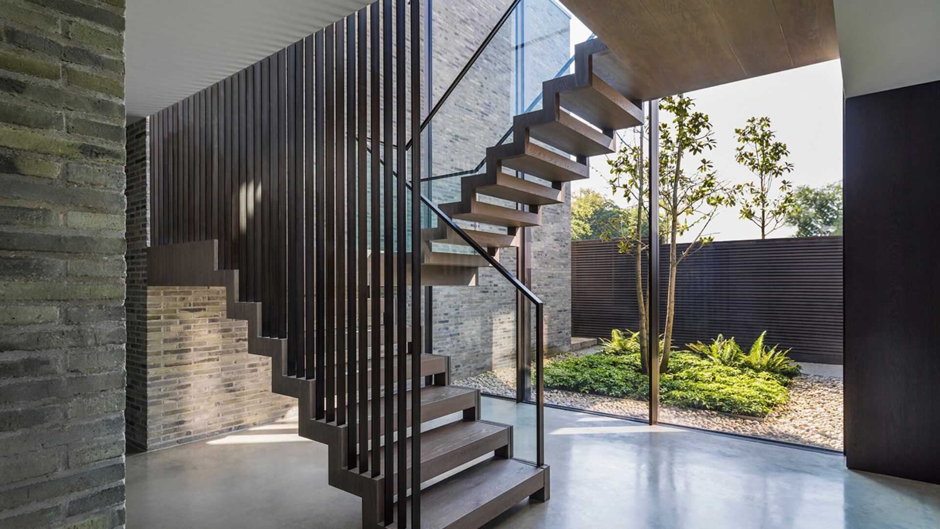 Modern staircase with grey waterstruck brick walls.