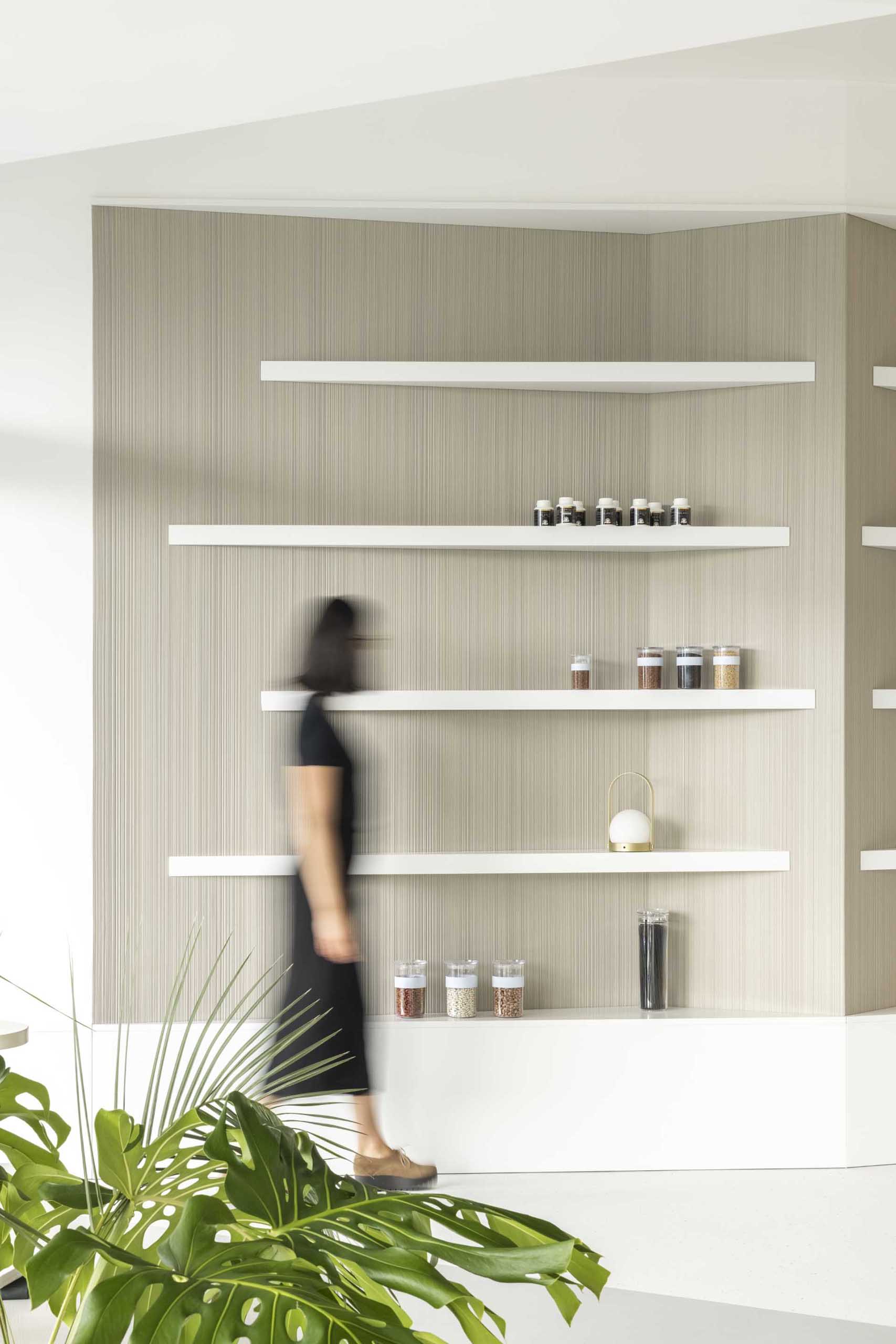A modern health clinic with a natural color palette includes white display shelves.