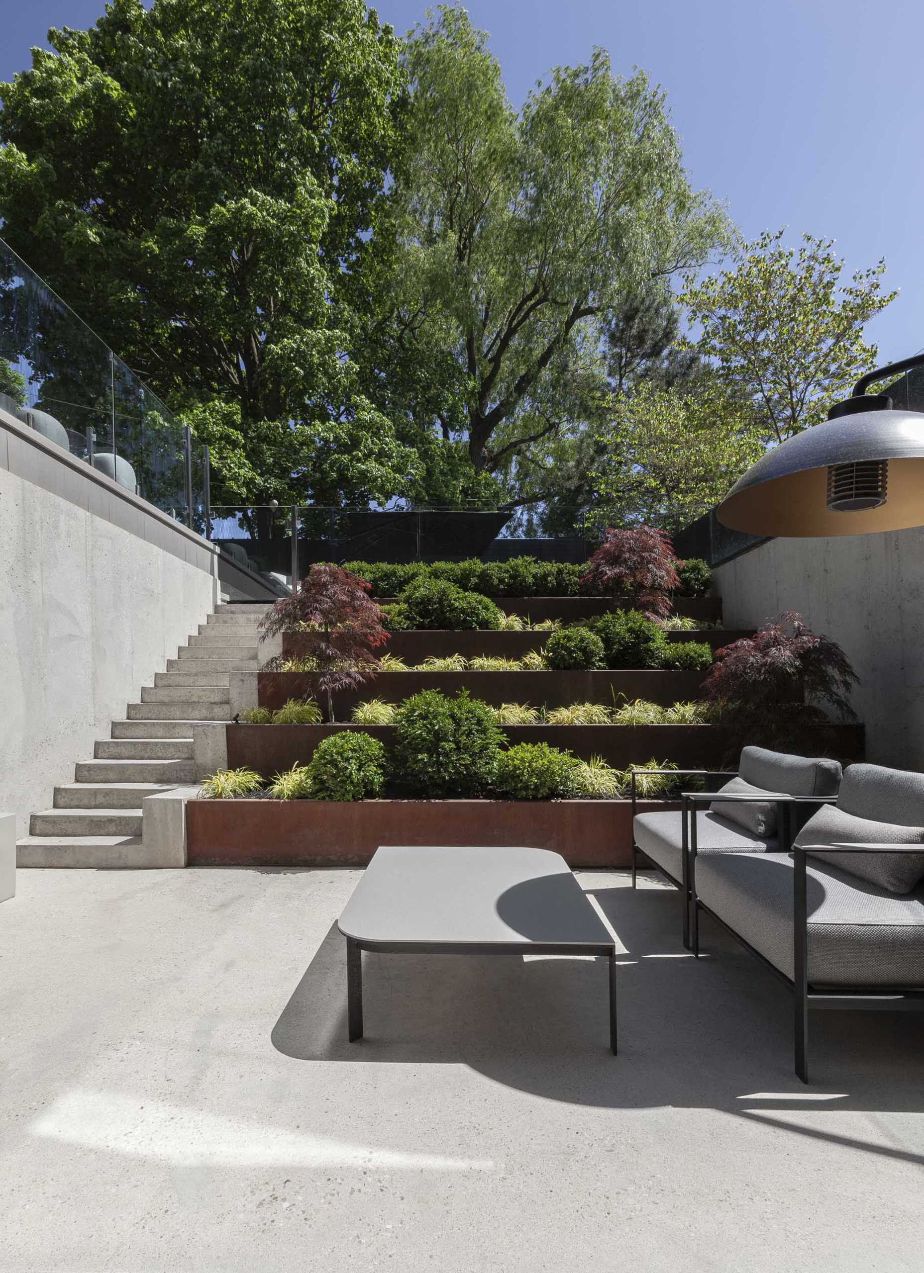 A modern yard with terraced weathered steel planters.