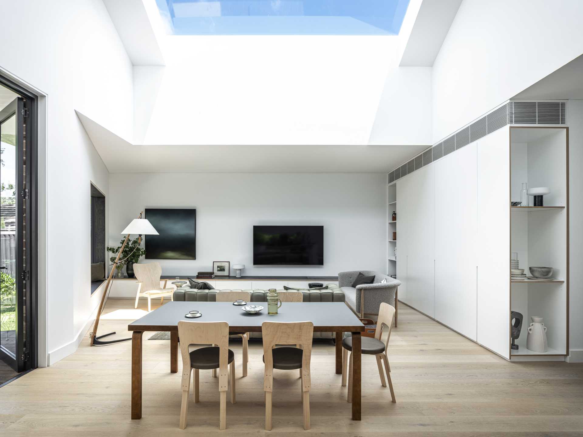 This dining area is located between the living room and the kitchen, and is positioned beneath a large skylight.