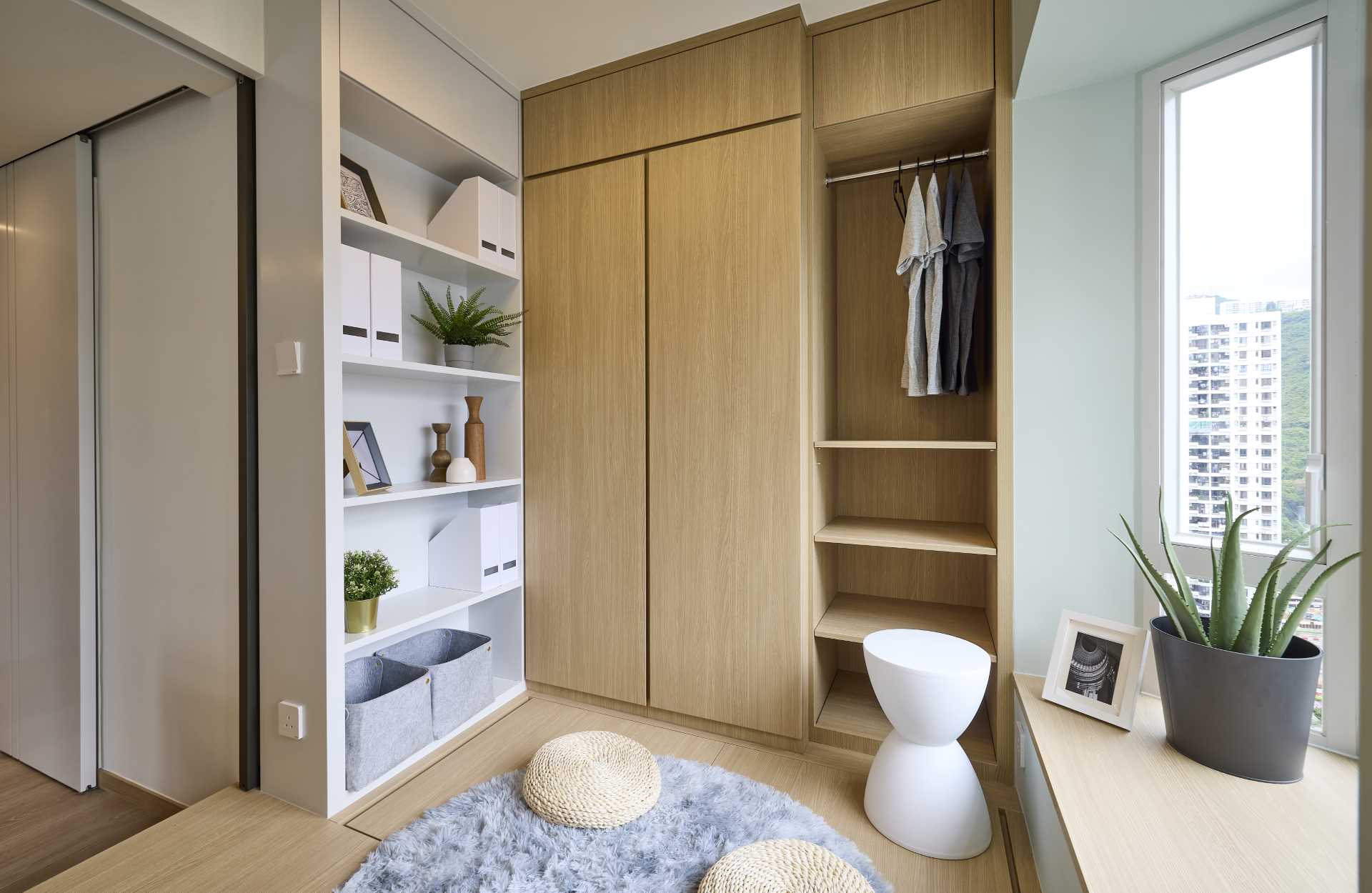 A wood closet and white bookshelf in a small apartment makes the most of the available space.