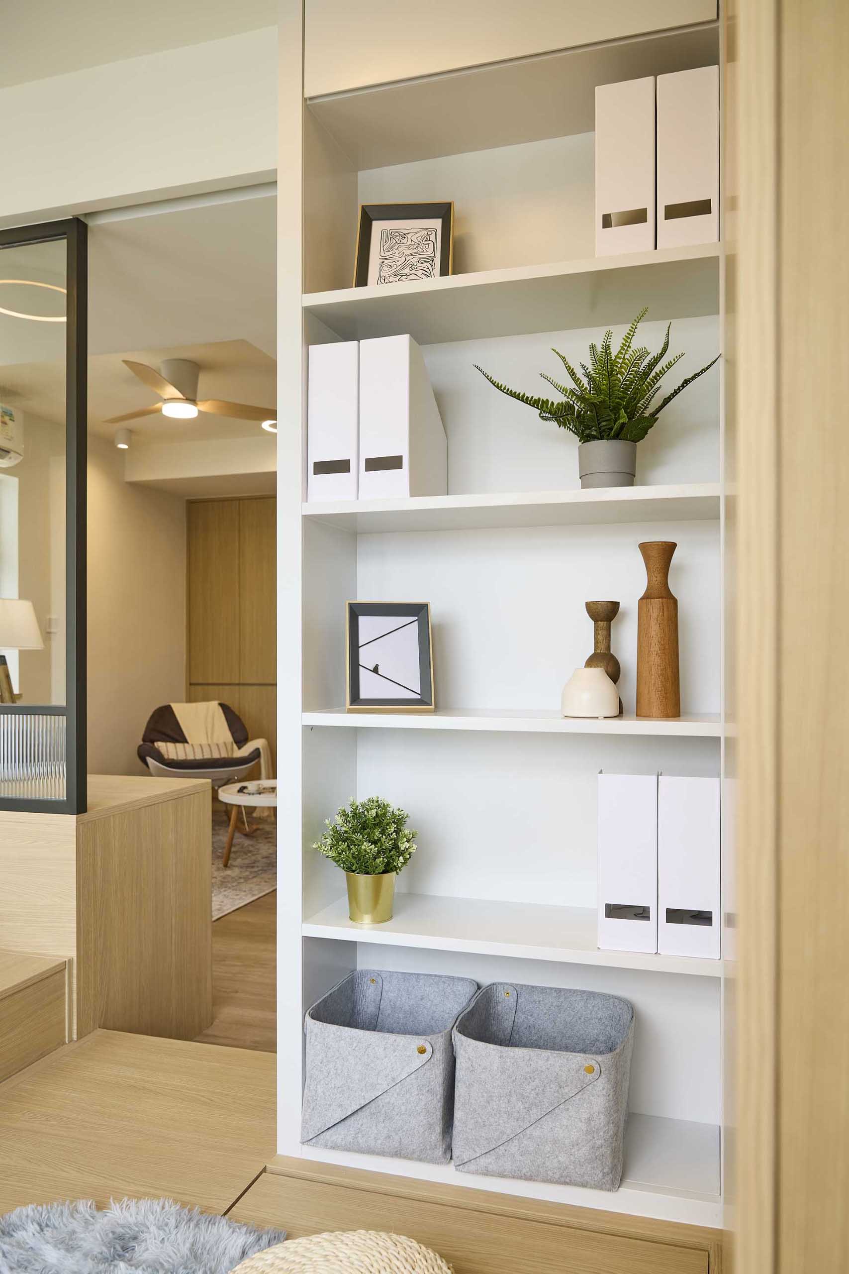 A wood closet and white bookshelf in a small apartment makes the most of the available space.