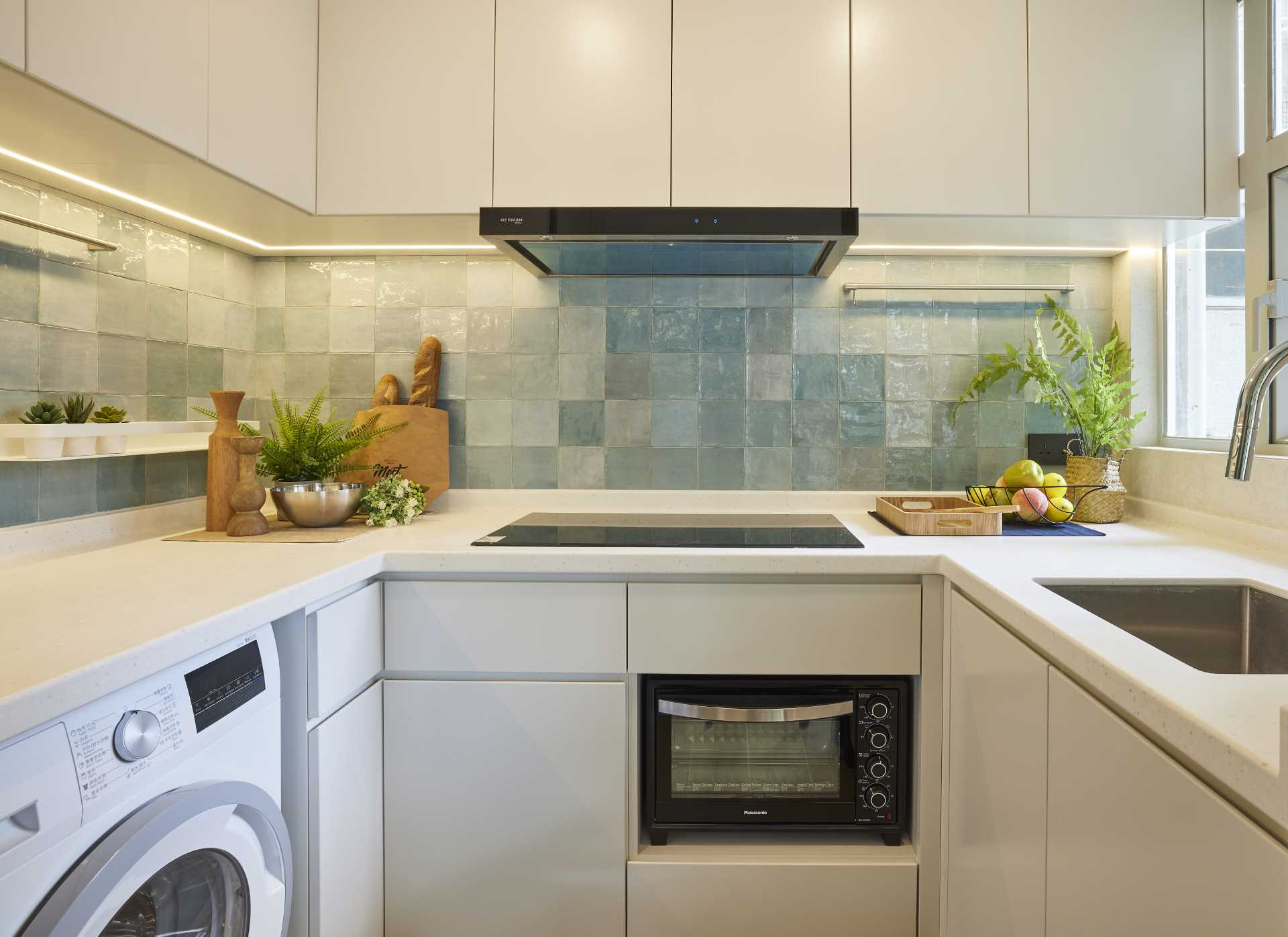 In this small kitchen, the aqua coloured handmade tiles juxtapose with the off-white spray painted kitchen cabinets, and helps to add layers and depth to the compact kitchen.