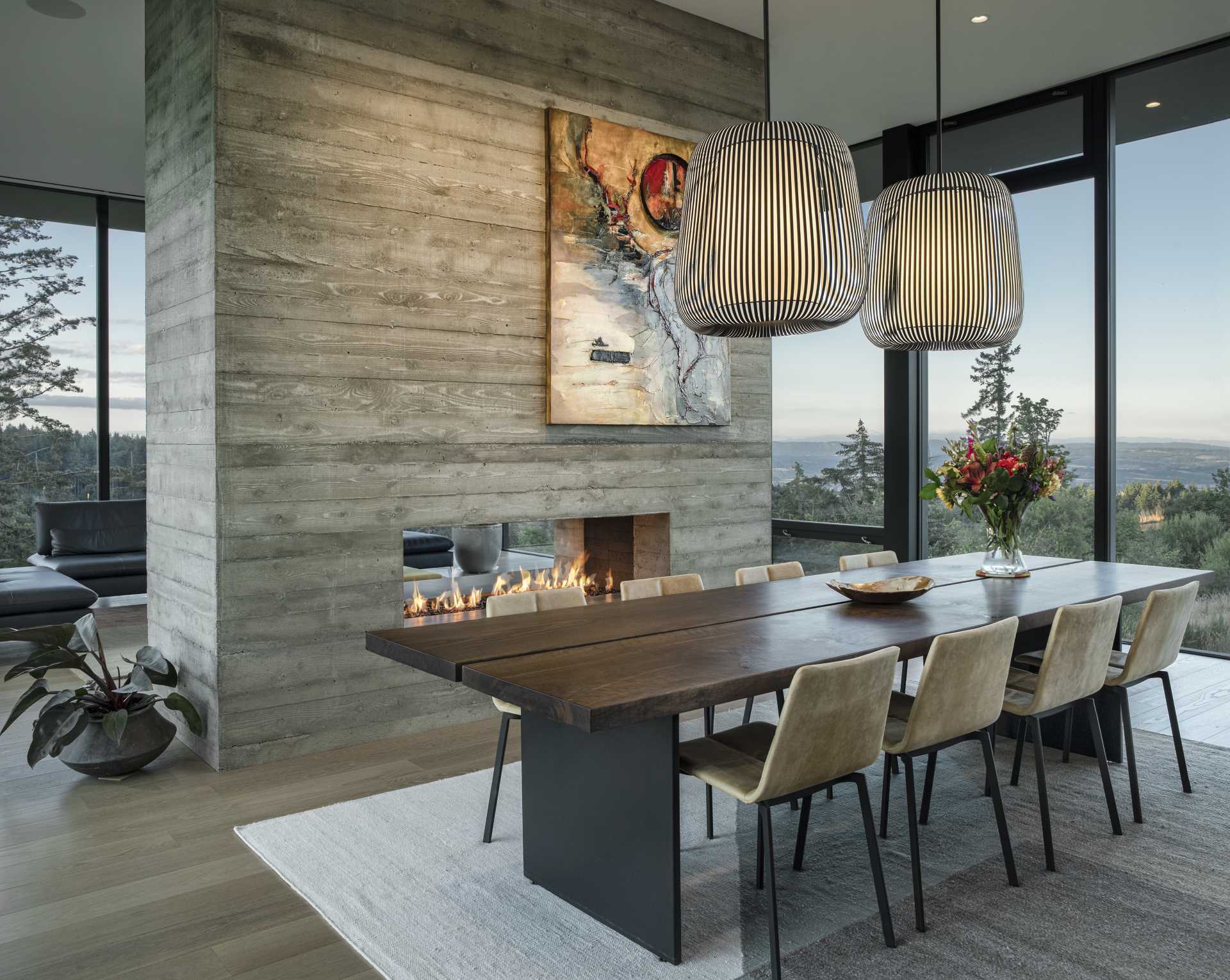 A board-formed, double-sided concrete fireplace can be enjoyed from living room and the dining room.