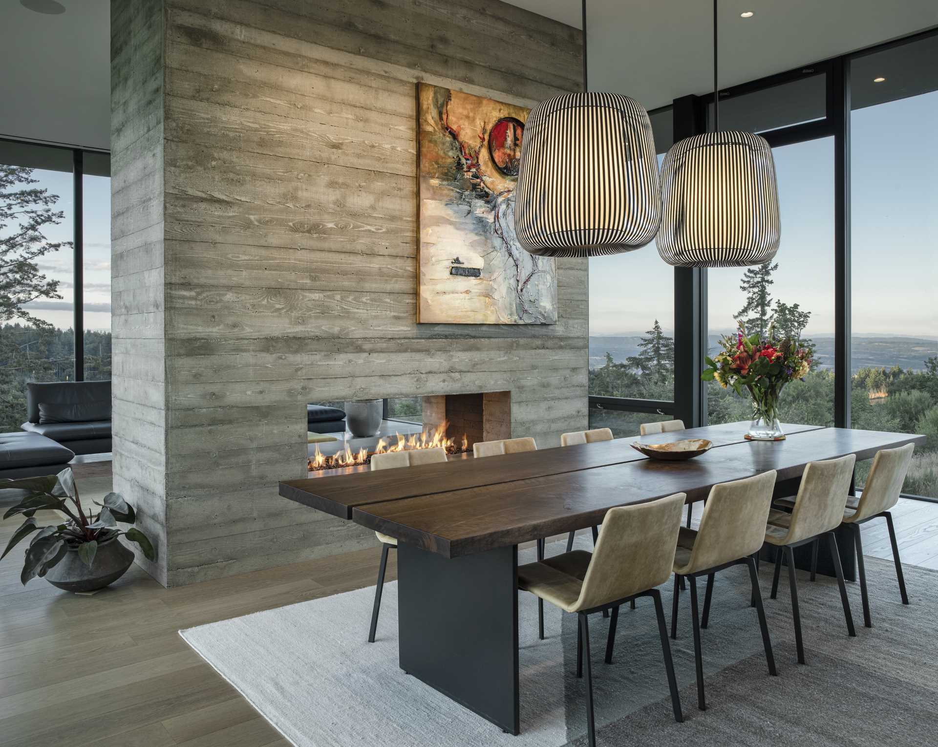 A board-formed, double-sided concrete fireplace can be enjoyed from living room and the dining room.