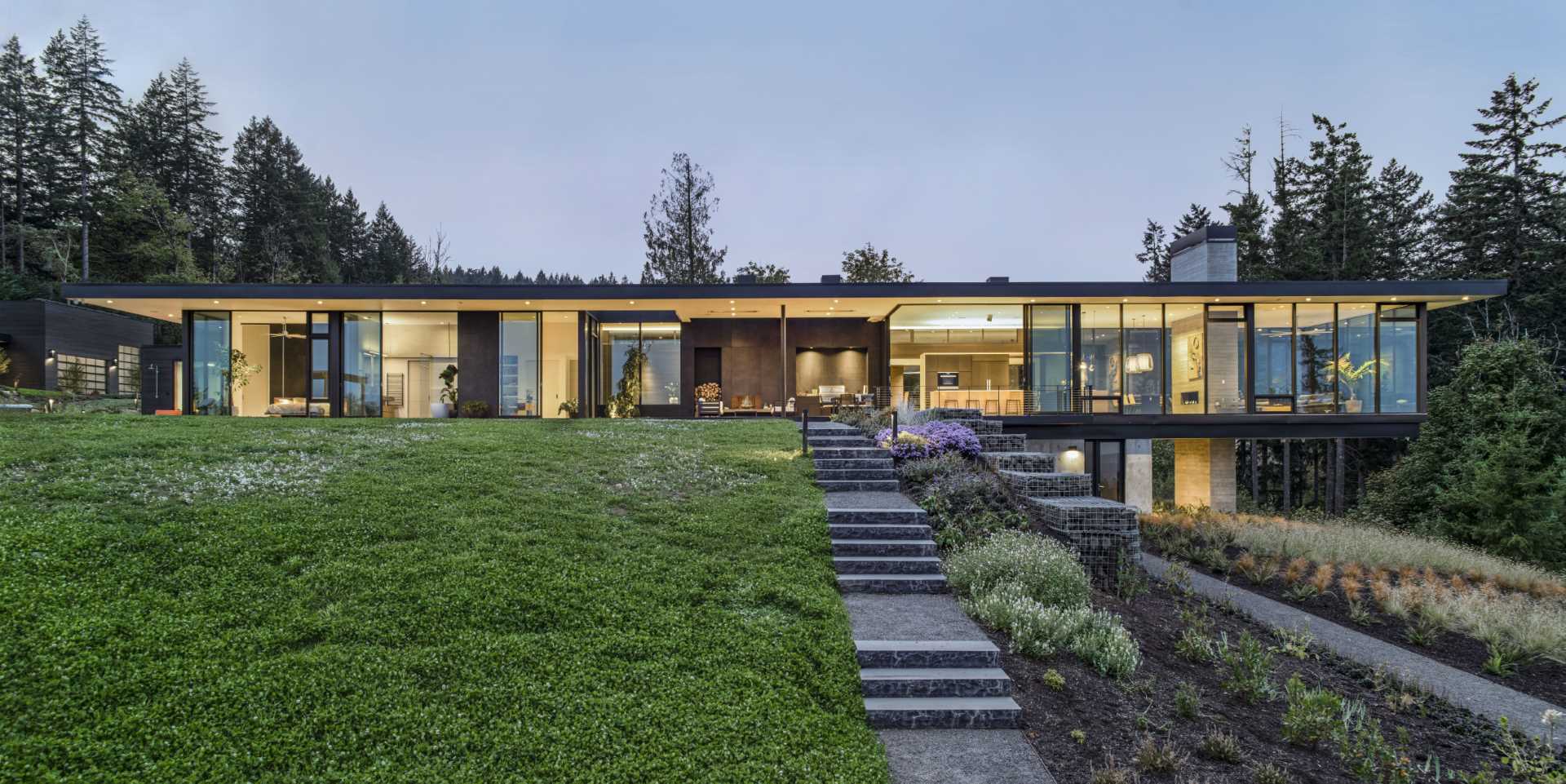 This modern home features floor-to-ceiling windows, and sliding doors are used in every east-facing room, all with the intent to blur the line between inside and out.