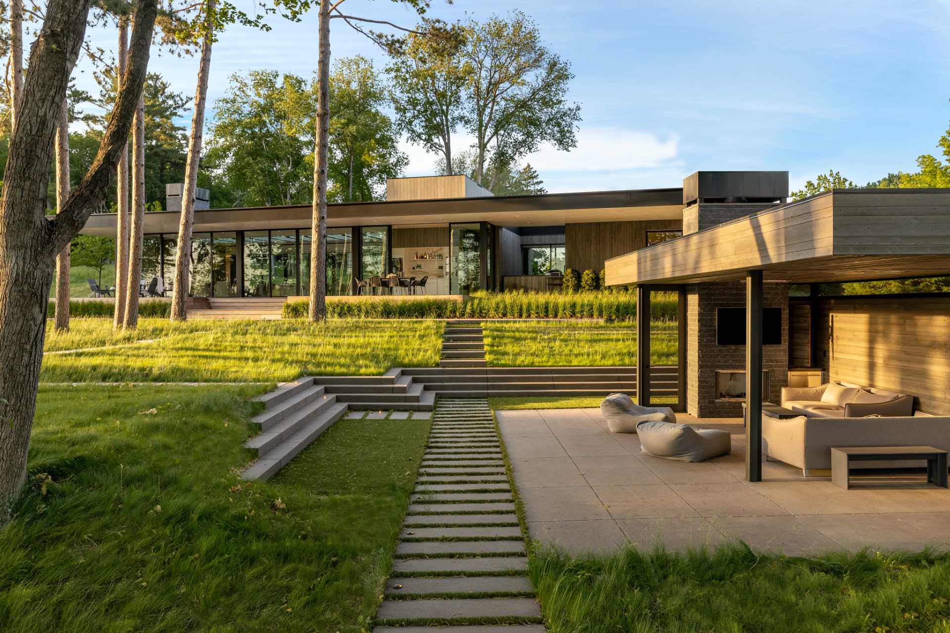 This terraced yard flows from the house, where there's a deck, down some stairs, and to a secondary covered outdoor entertaining area with a fireplace, tv, and lounge.