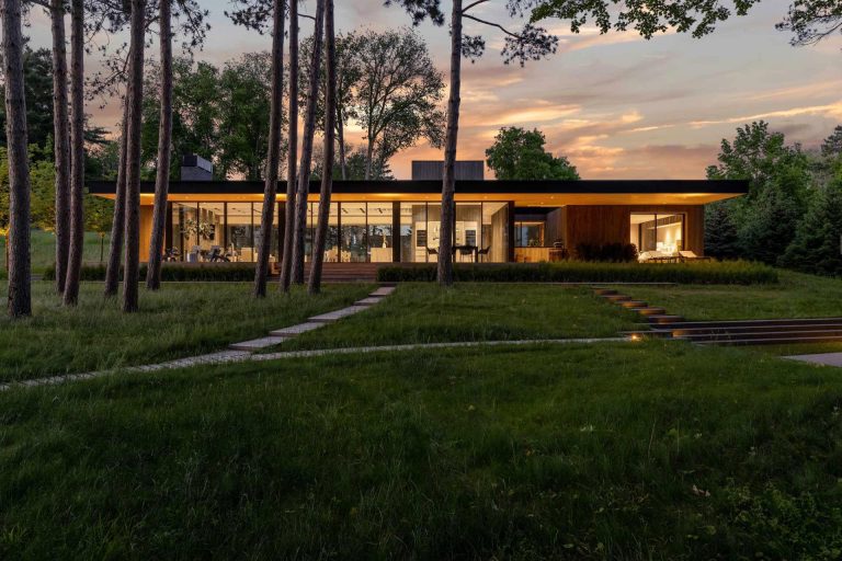 A Deep Overhanging Roof Covers The Glass Walls Of This Lake House