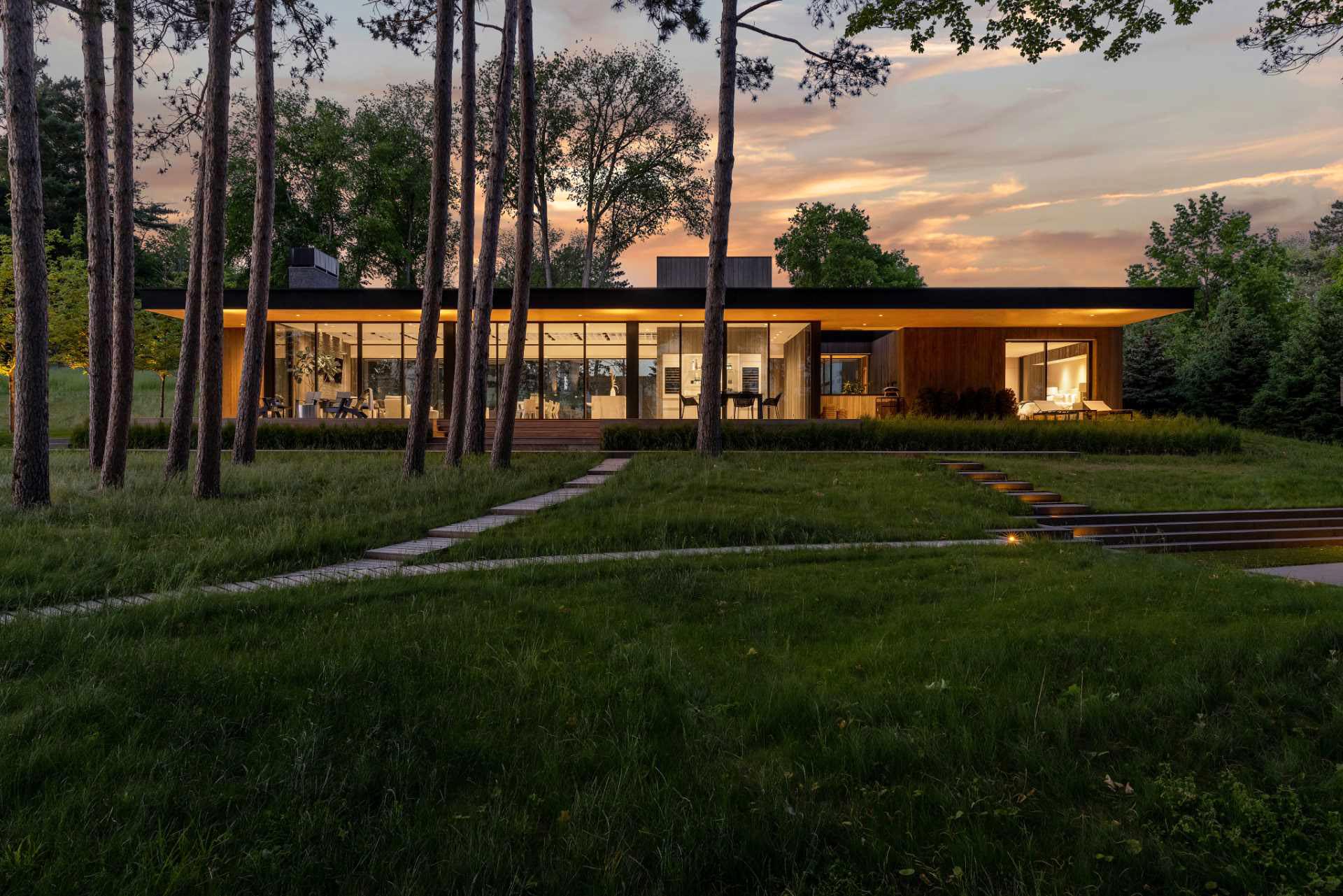 A modern house with glass walls and sliding doors.