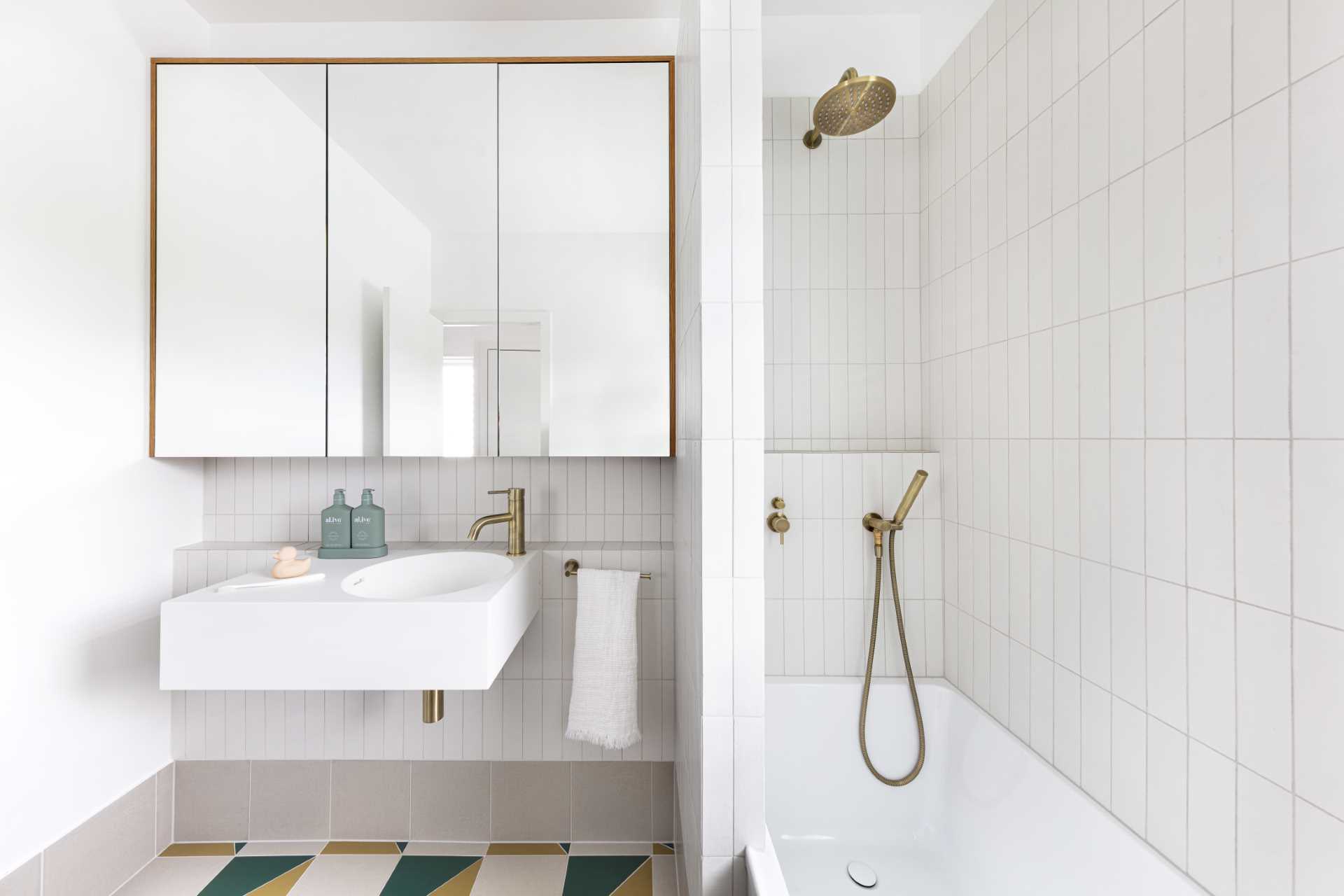 This kids bathroom has a neutral palette, however colorful floor tiles add a hint of fun.