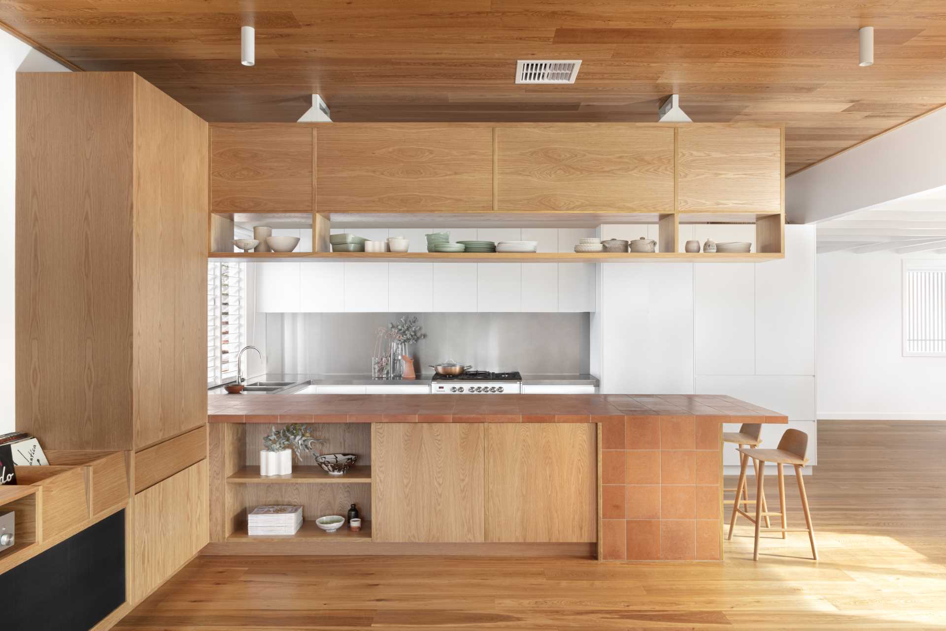 This kitchen design includes a peninsula that's clad in terracotta tiles.