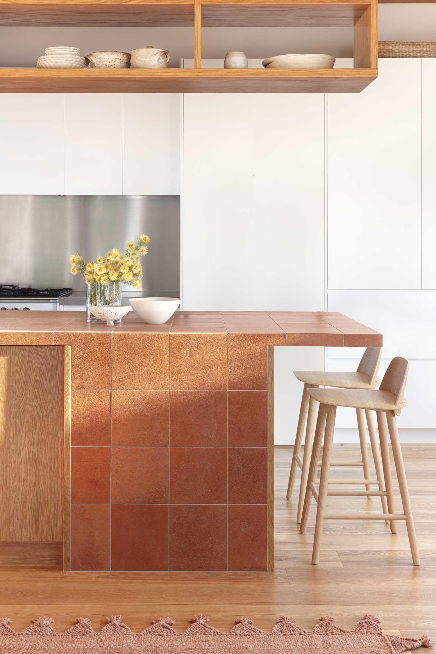 This kitchen design includes a peninsula that's clad in terracotta tiles.