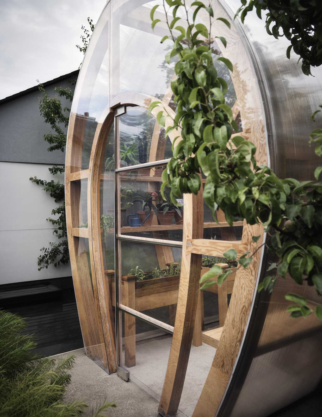 A modern and modular greenhouse design for a backyard.