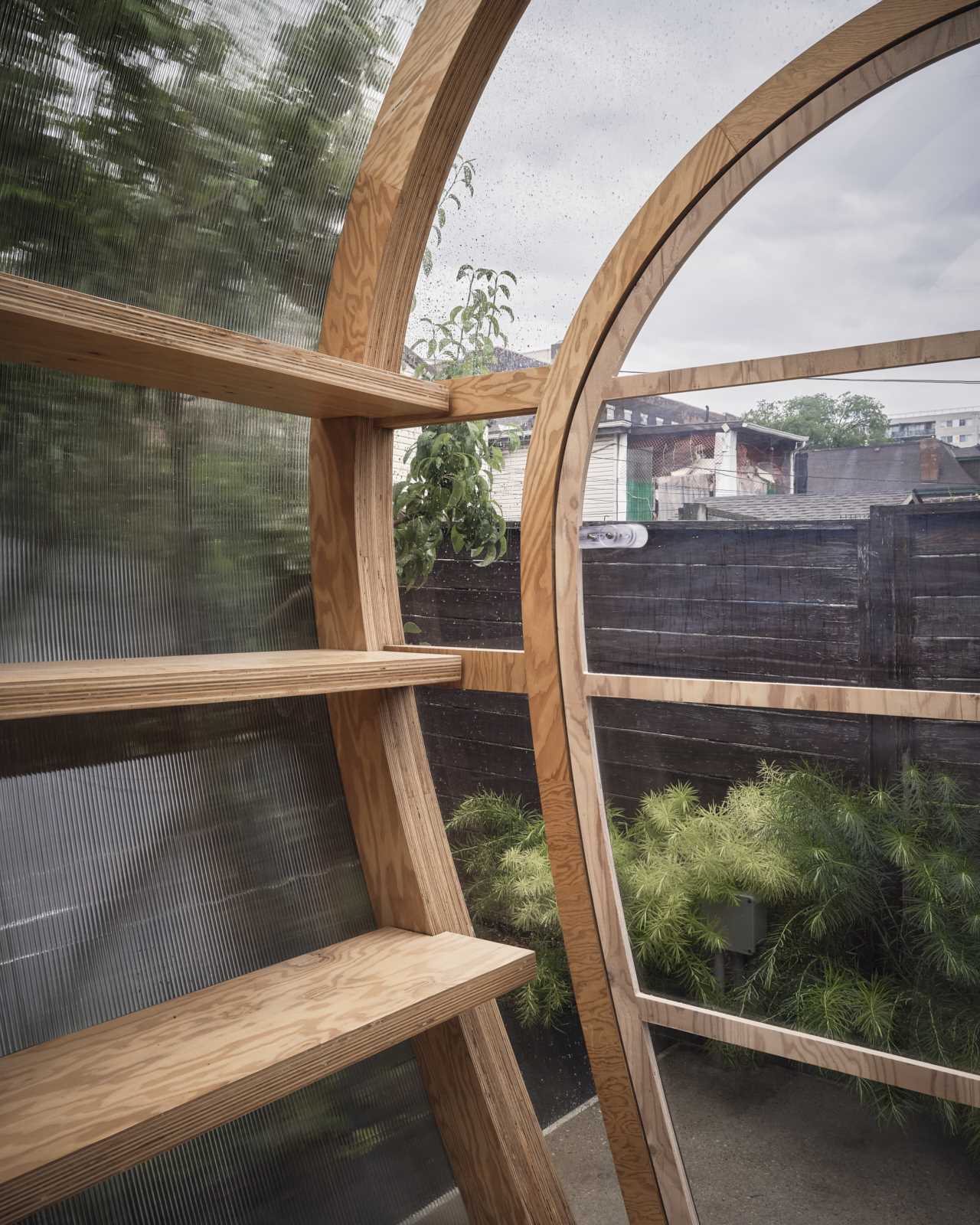 A modular greenhouse with marine-grade plywood ribs and shelves, and covered in a standard 10mm polycarbonate sheet.