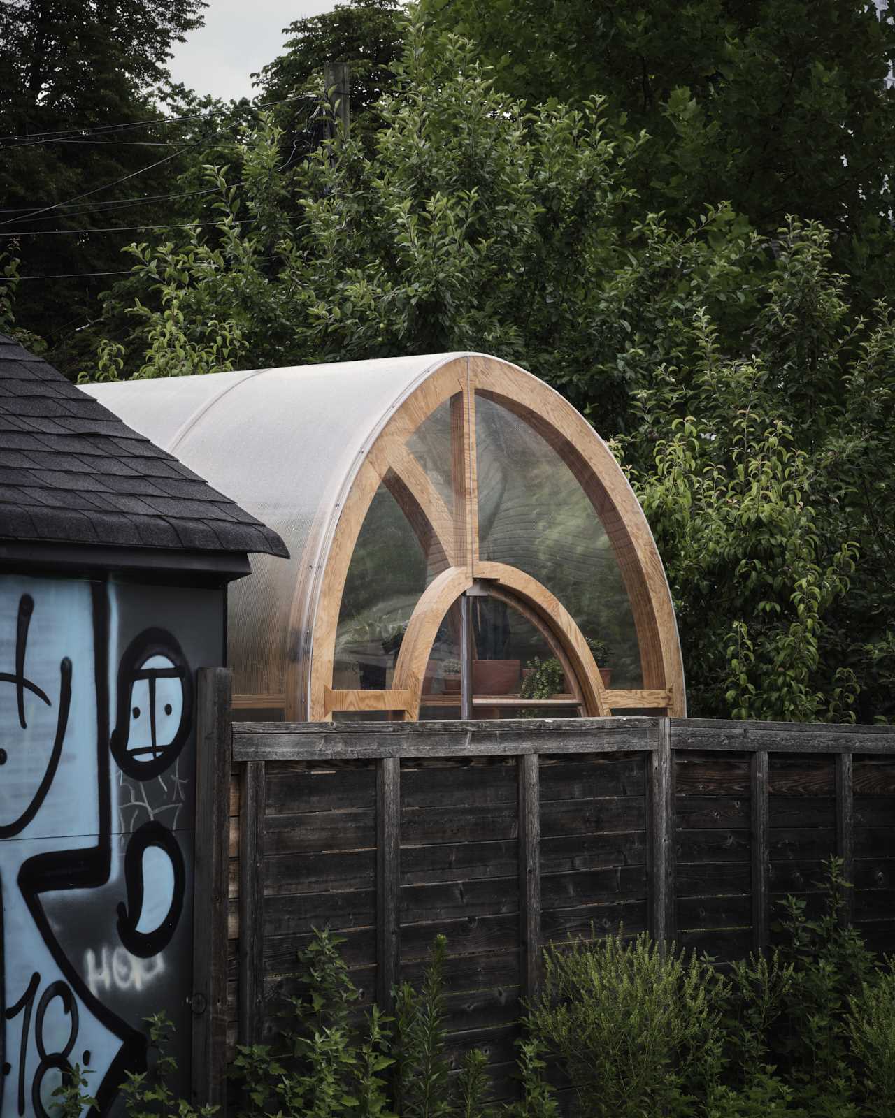 A modern and modular greenhouse design with a curved shape made from marine-grade plywood ribs and polycarbonate sheet.