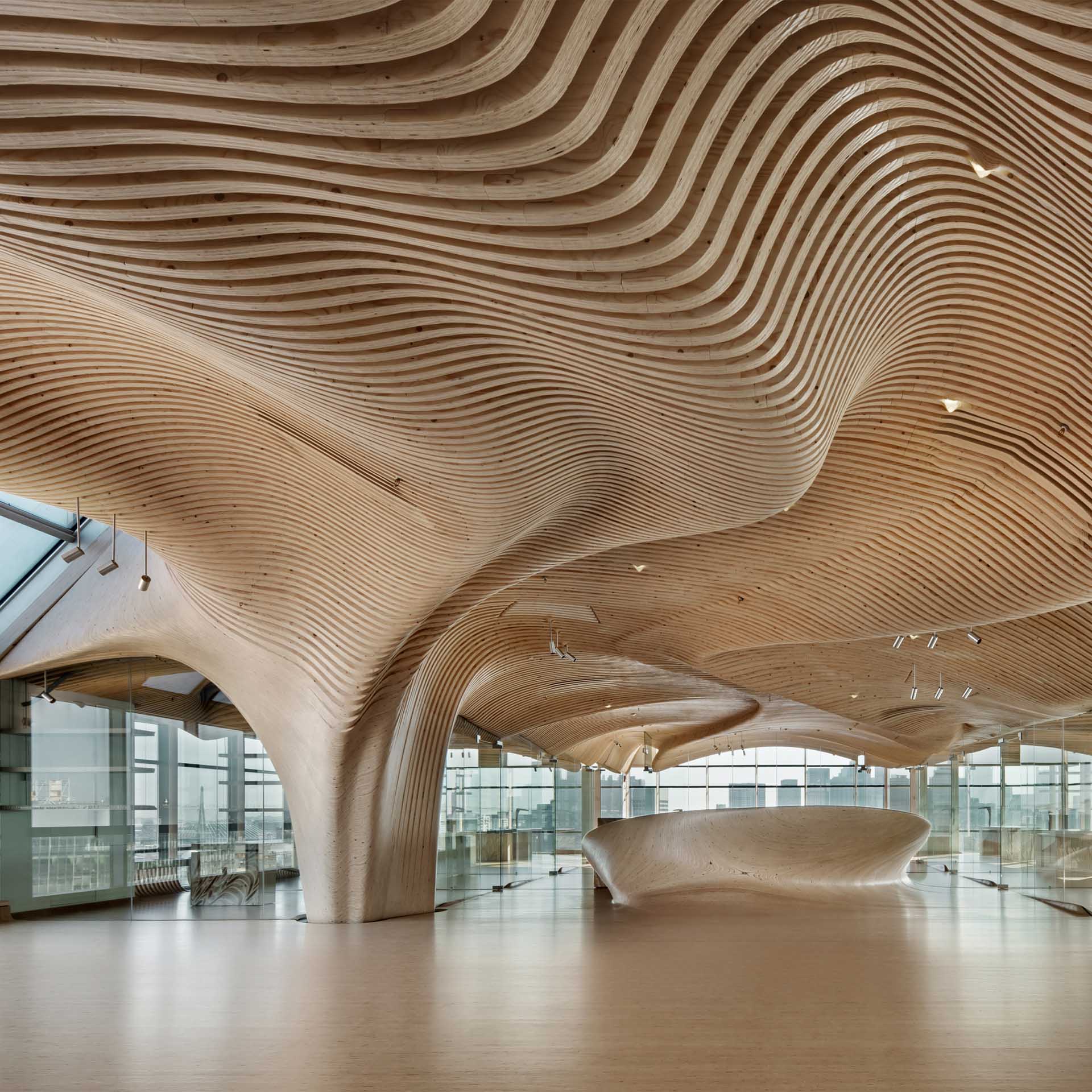 A modern office building with sculptural wood ceiling.