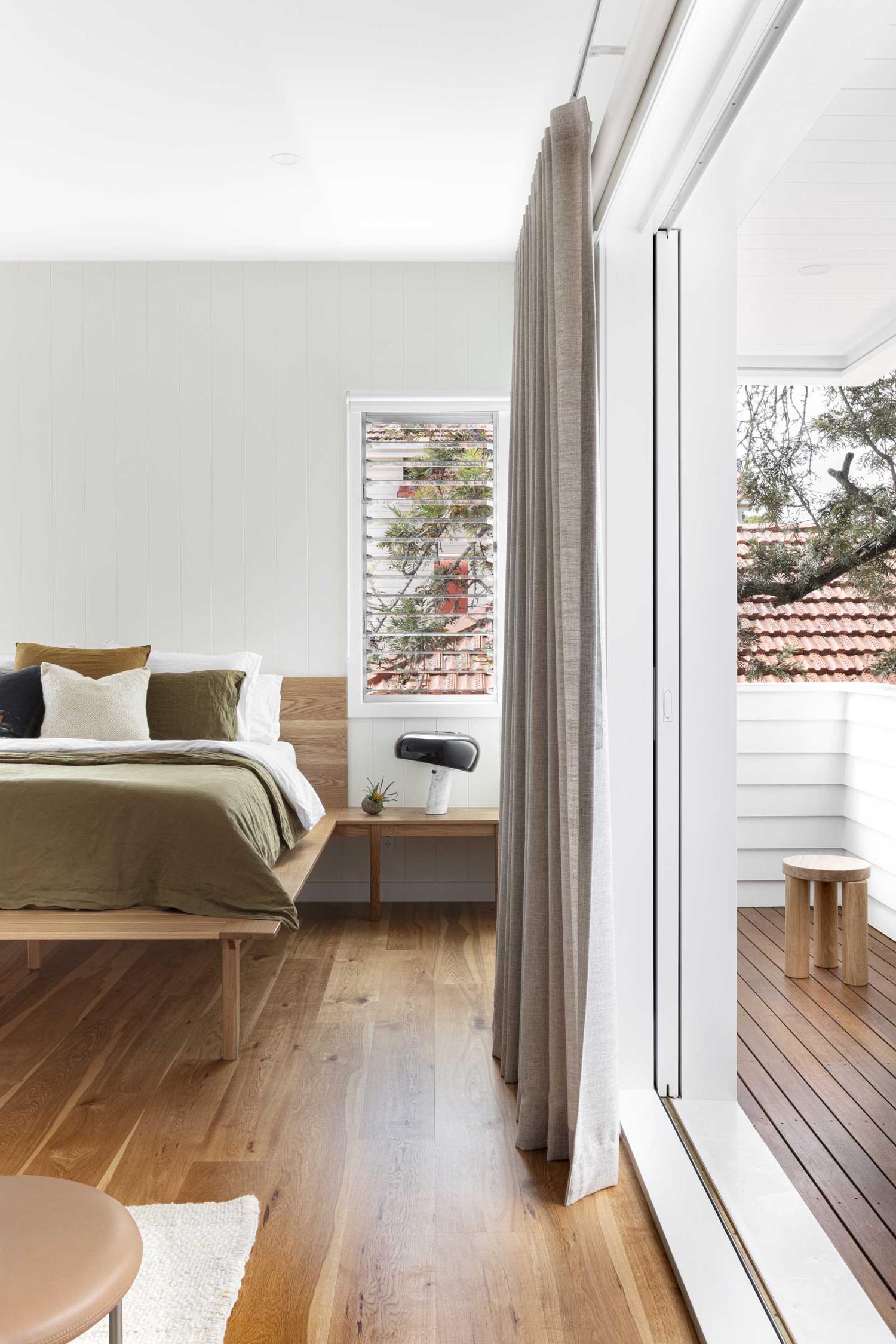 A modern primary bedroom includes its own private balcony.