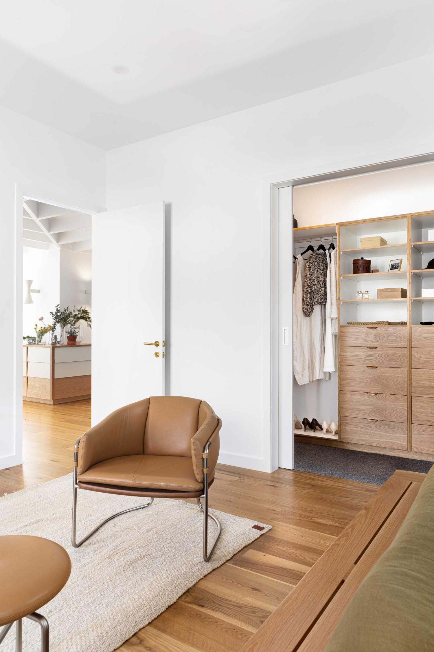 A walk-in closet with built-in wood shelves and drawers.