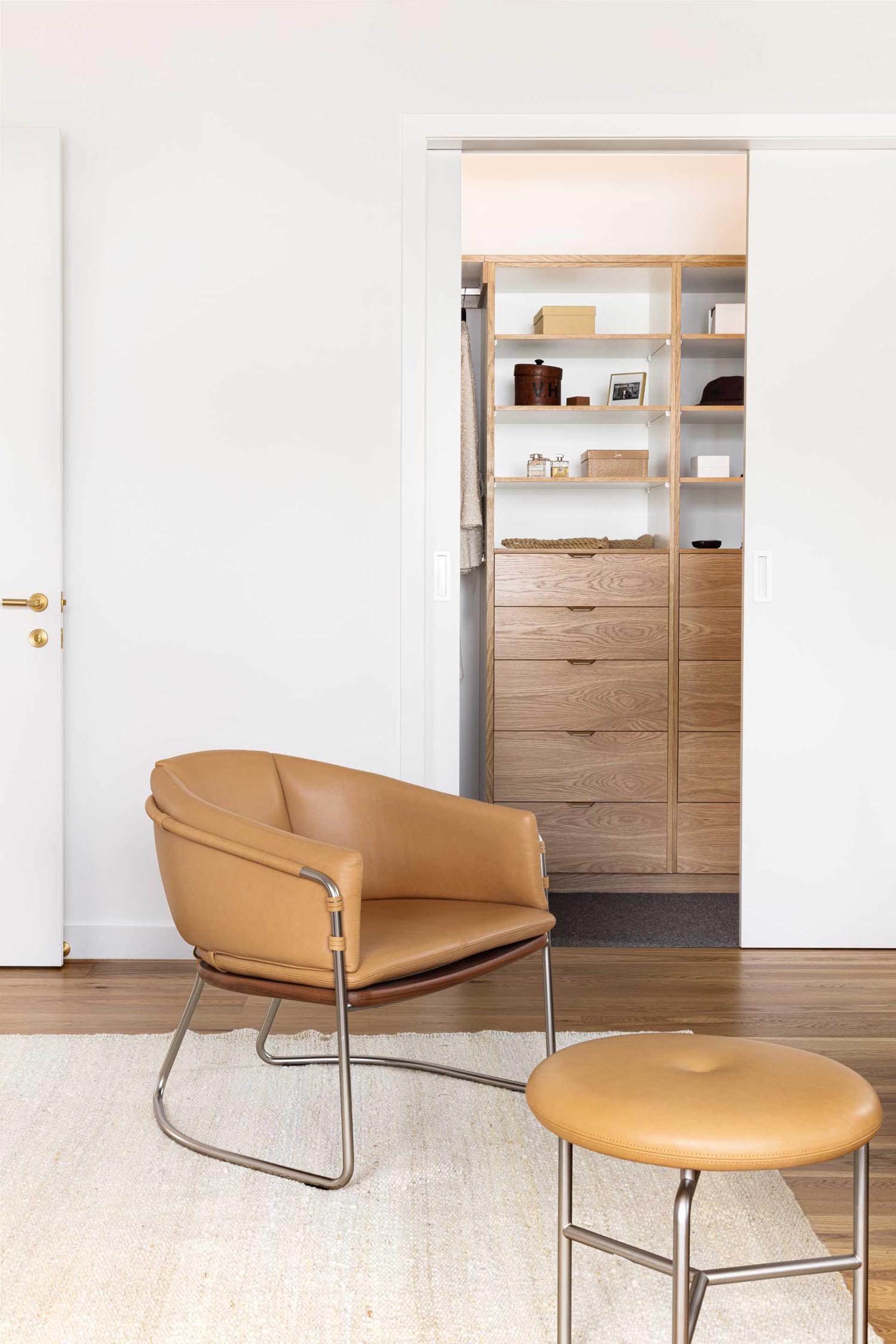 A walk-in closet with built-in wood shelves and drawers.