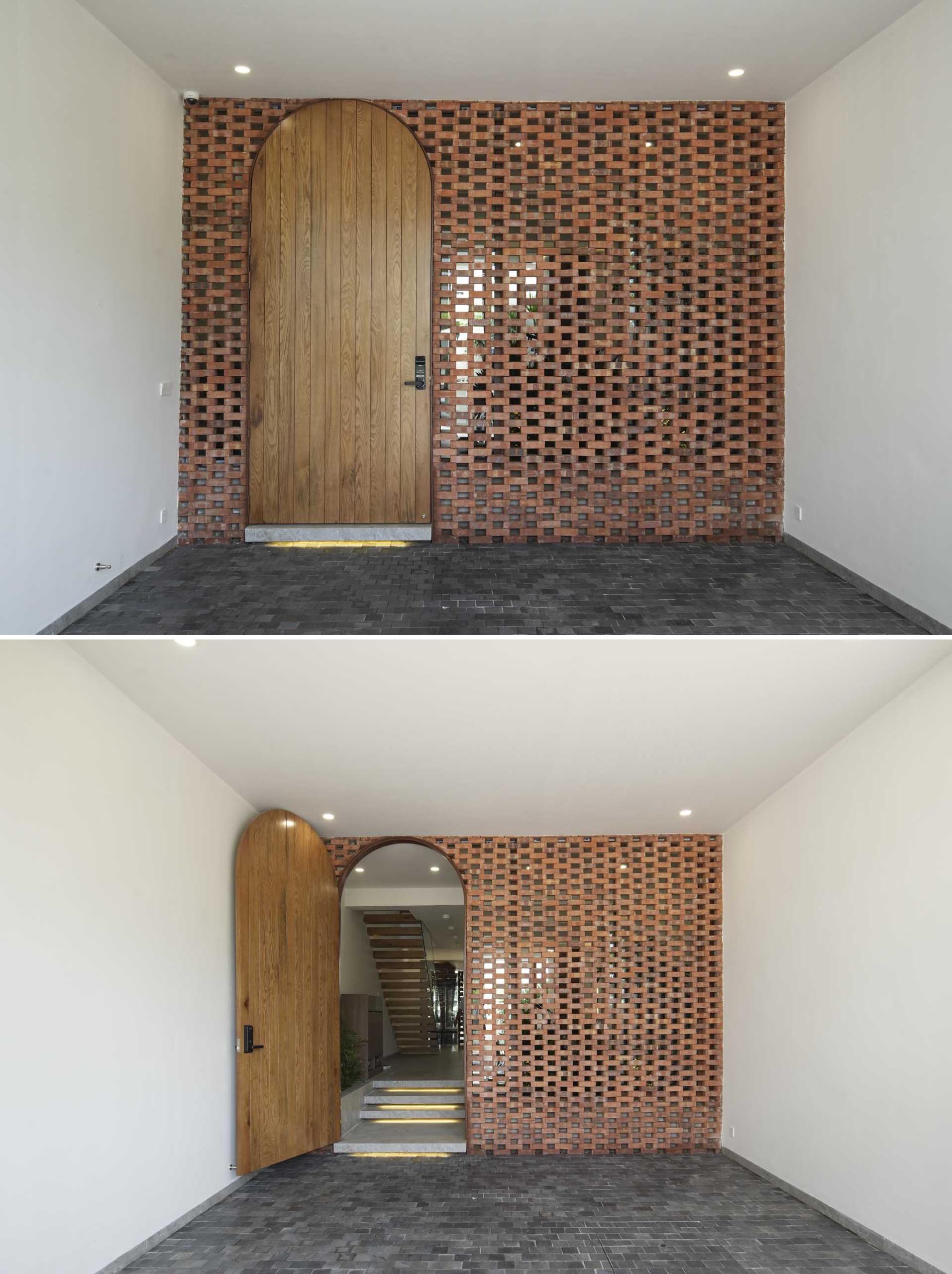 A modern entryway with a block wall and an arched wood door.