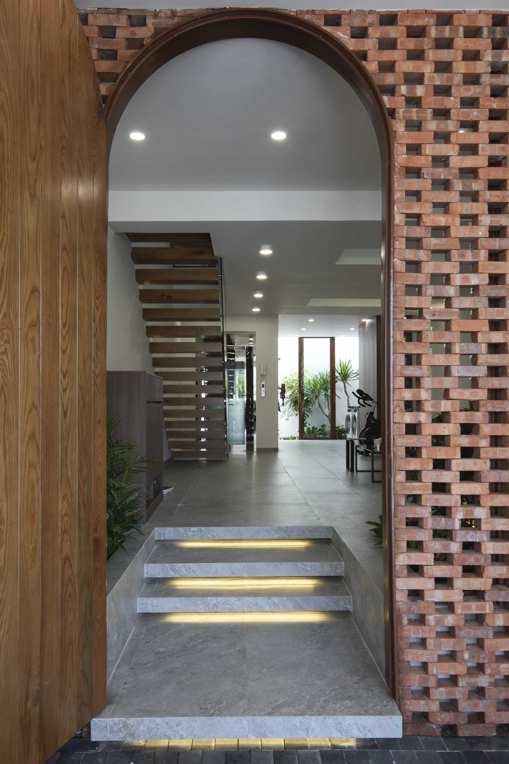 A modern entryway with an arched doorway and built-in planters.