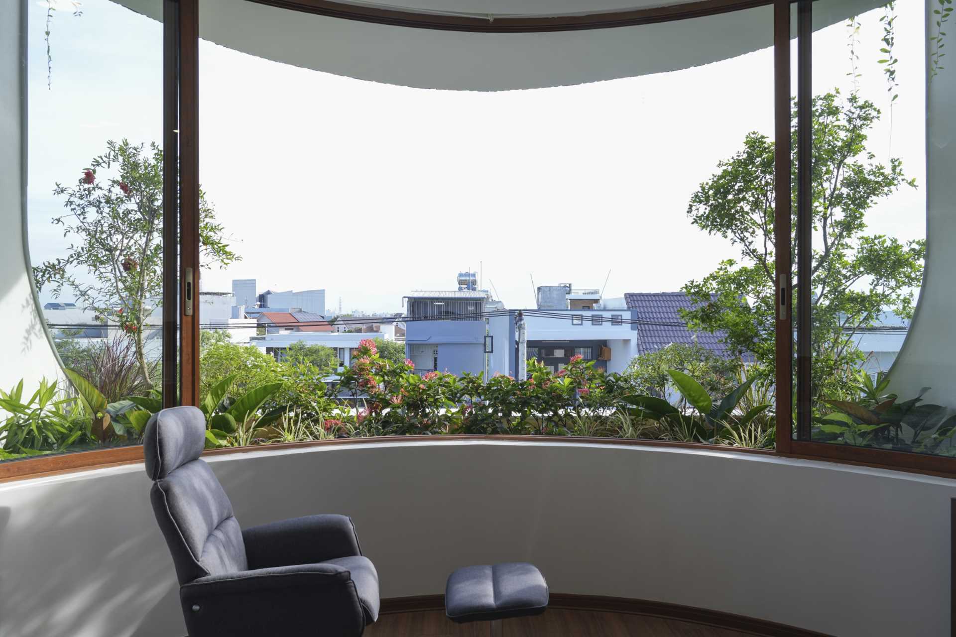 A modern house with a curved window and built-in planters.