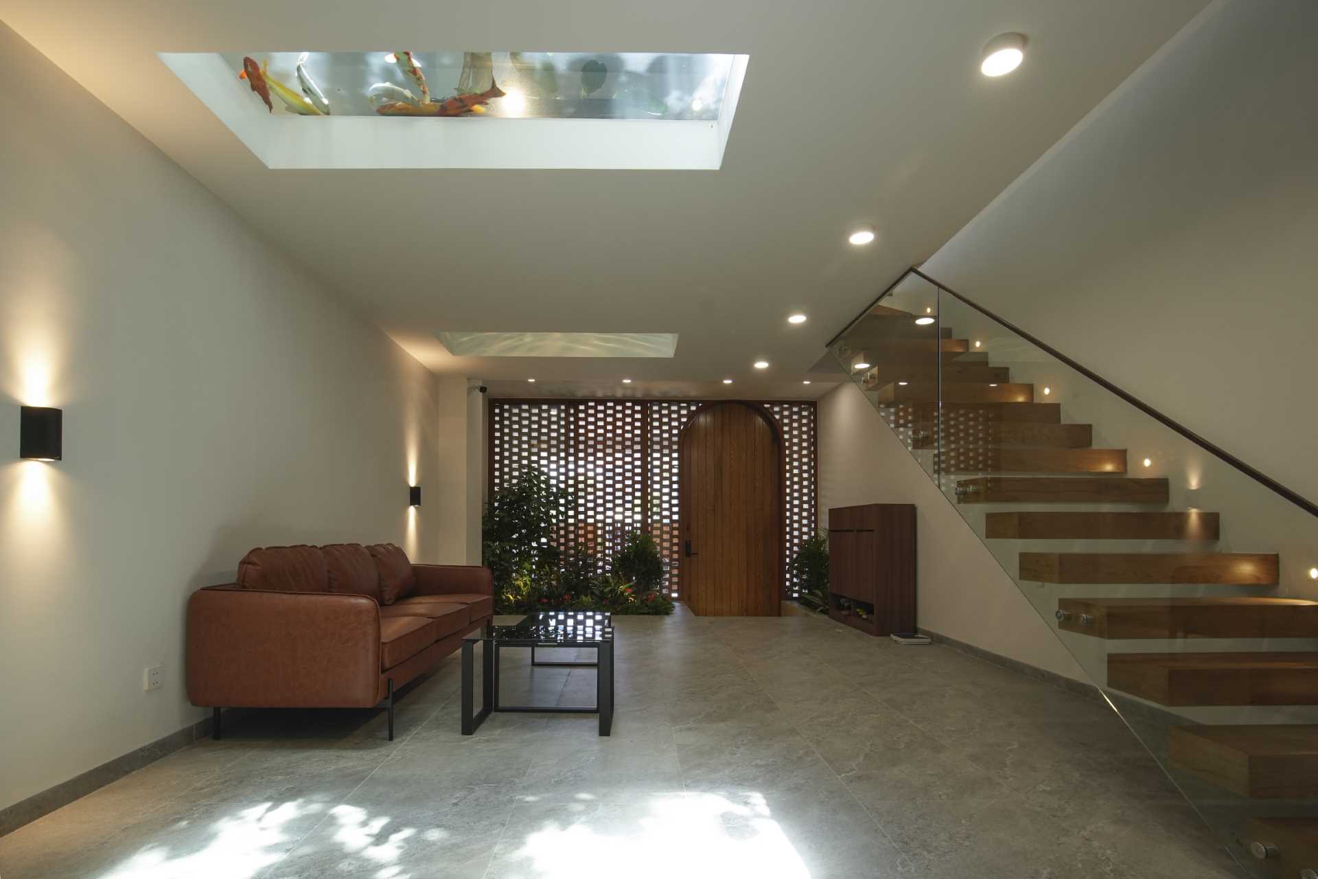 A modern entryway with a living room that has a view of the koi pond above.