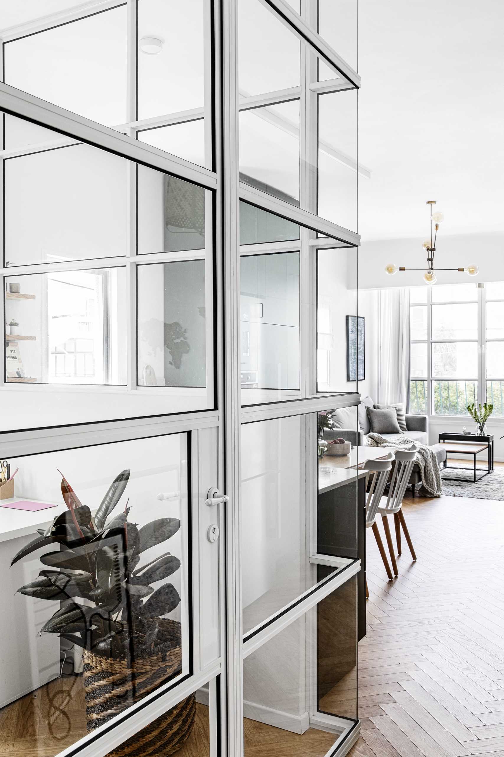 A glass-enclosed-home office with white-framed interior windows.